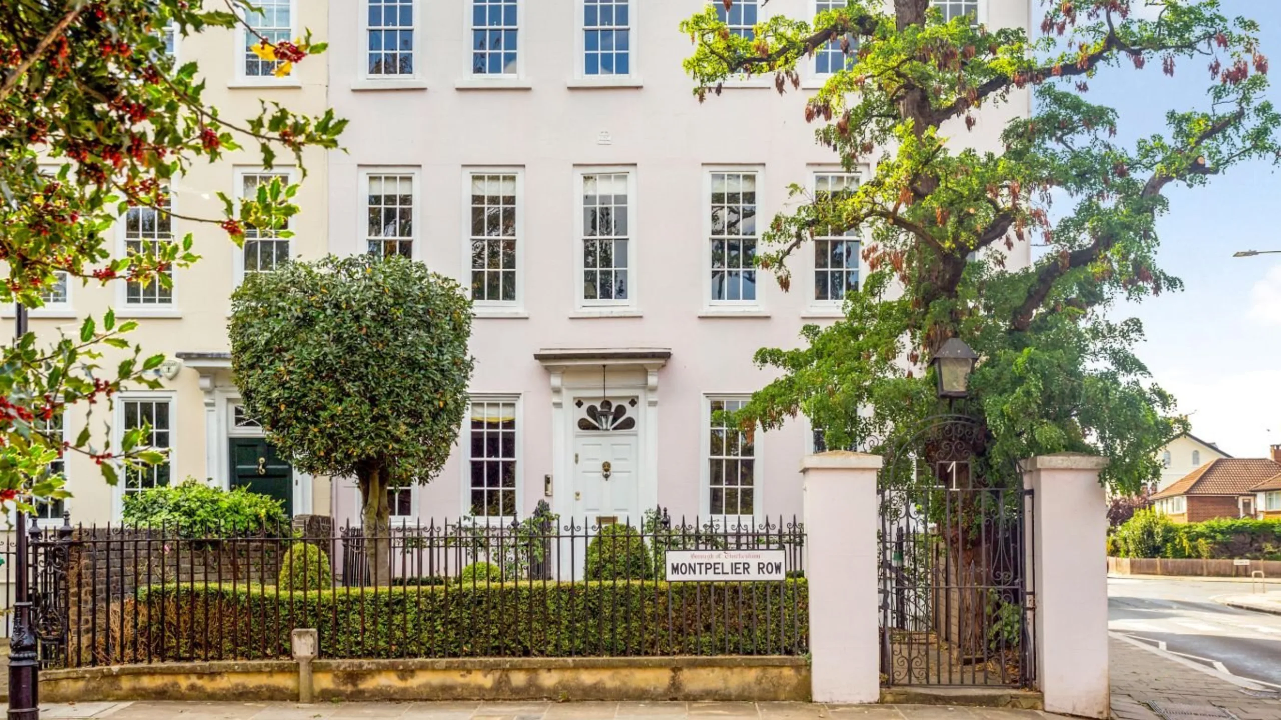 Exterior of Georgian townhouse with white walls and trees in the background