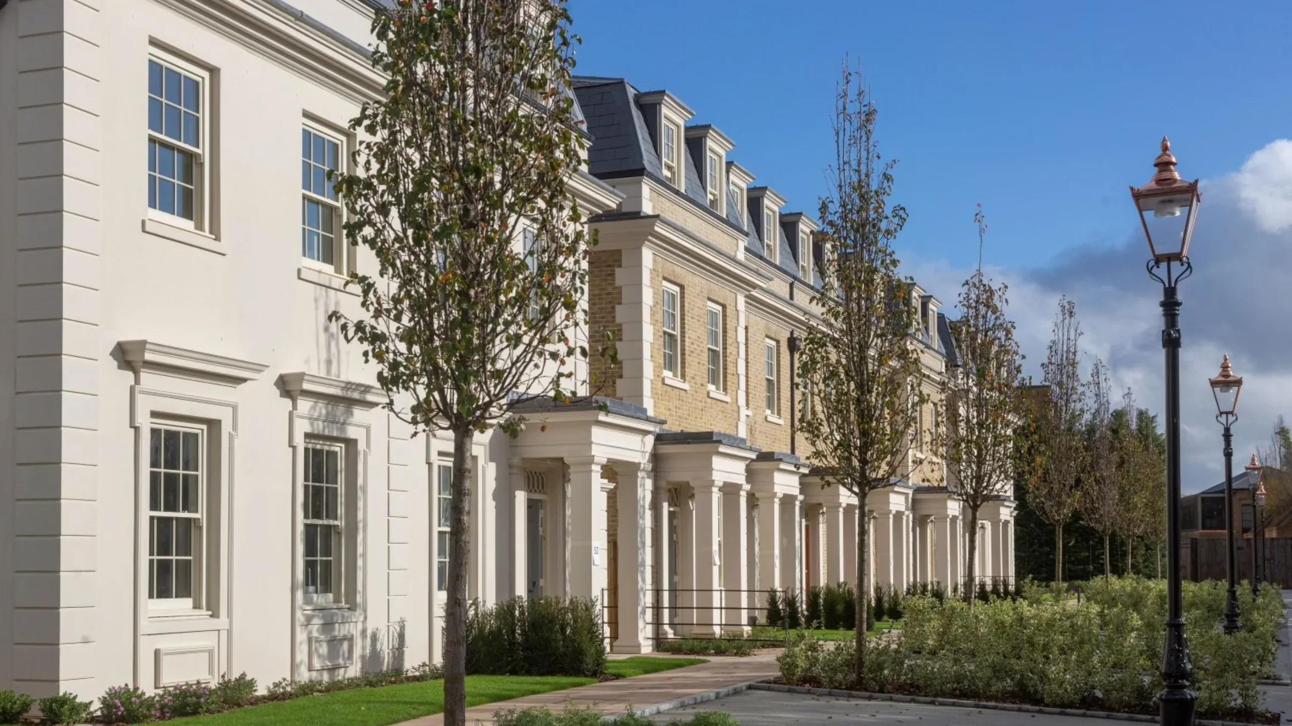 Row of cream period homes with small trees in front