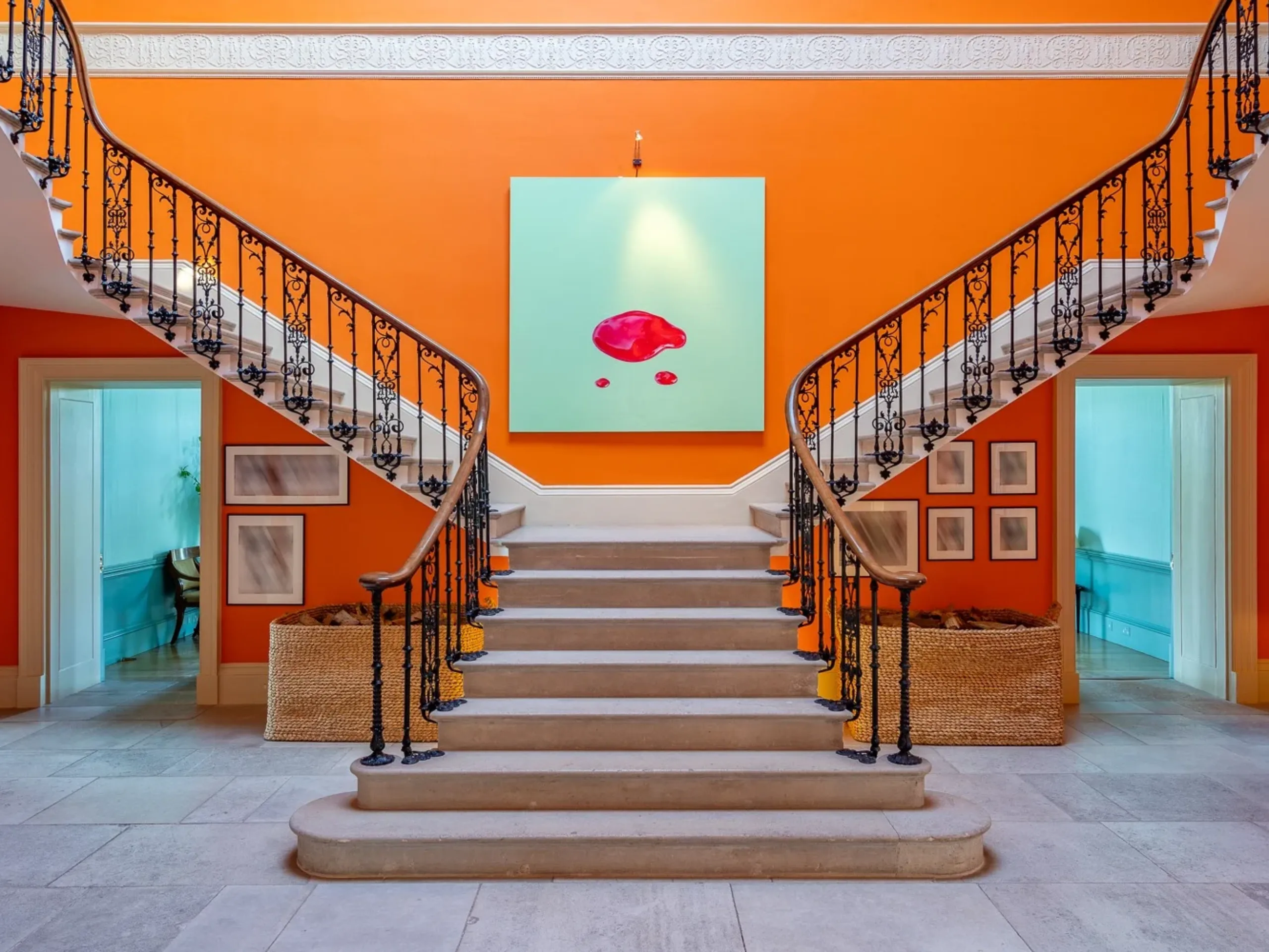 Residential lobby with a double staircase and orange coloured walls