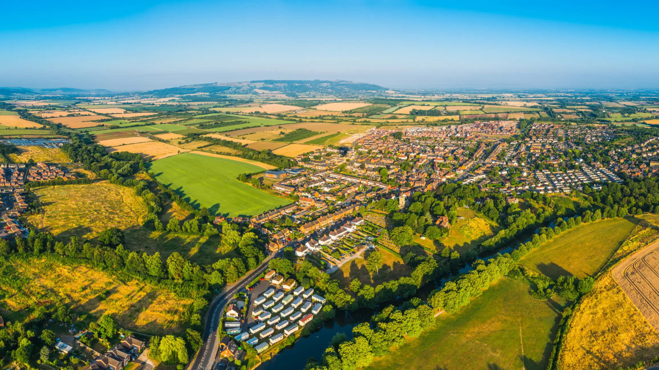 aerial-panorama-over-suburban-homes-green-pasture-golden-crop-fields