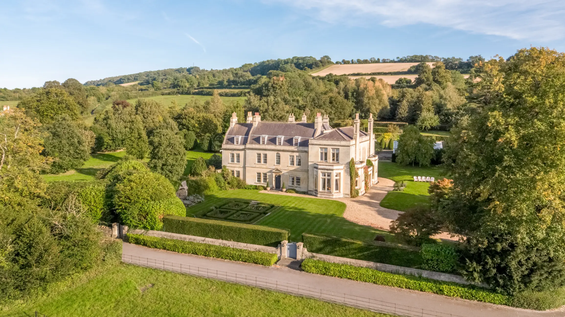 Large period home with expansive green grounds filled with trees