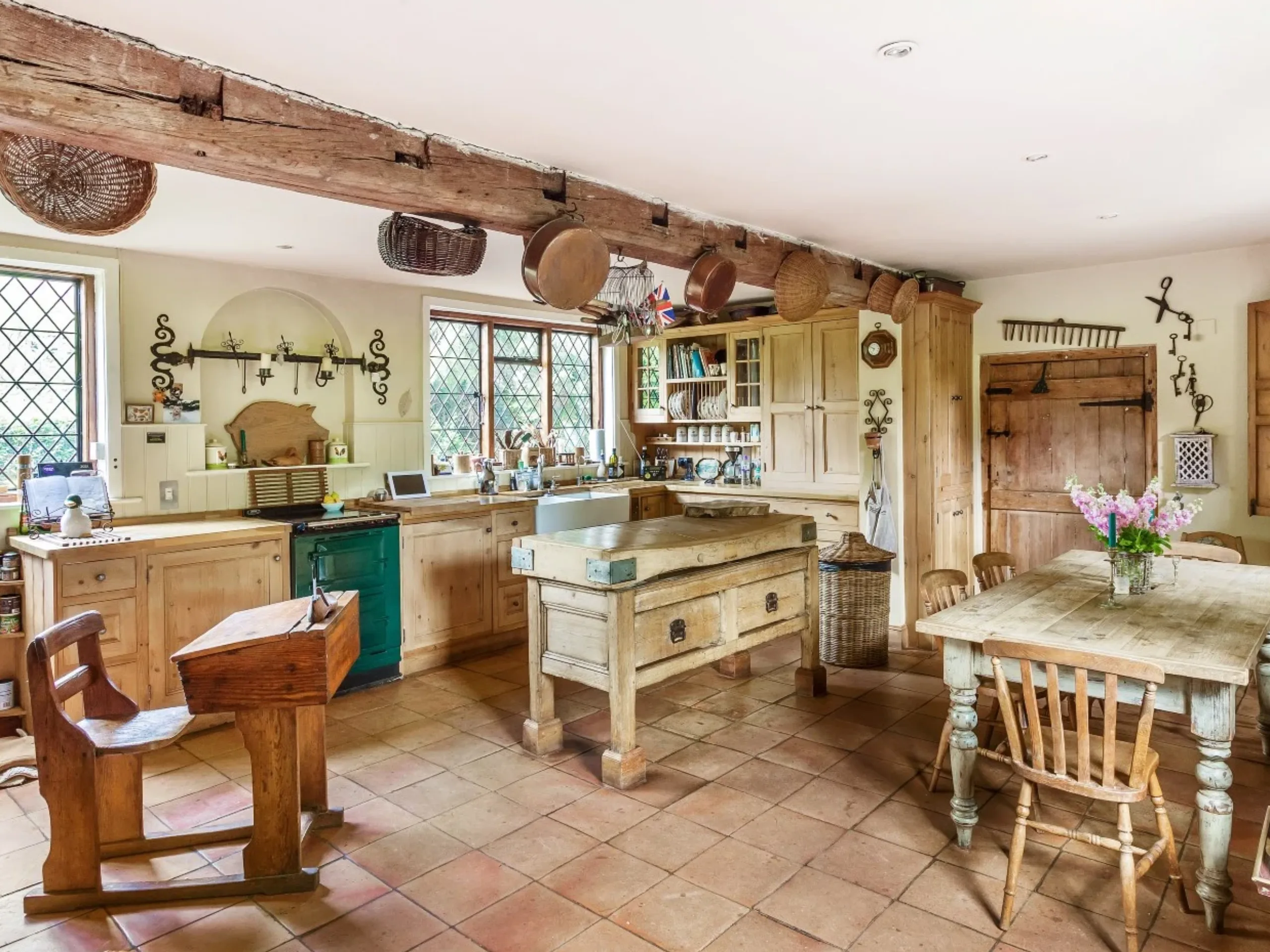 Farmhouse kitchen with a wooden beam, a large wooden table and butchers block