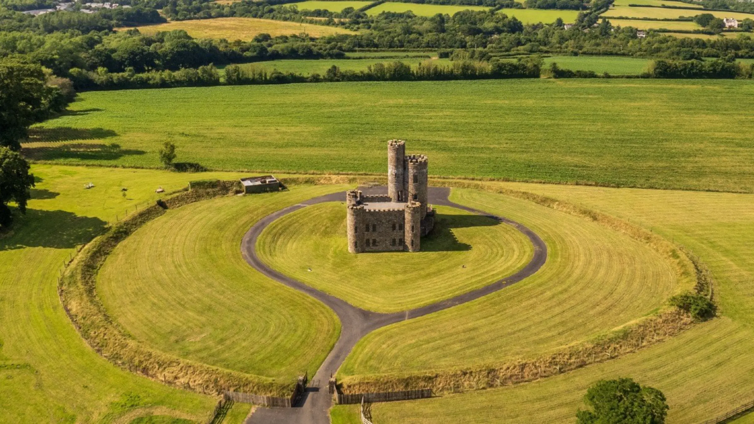 Ariel view of a castle surrounded by trees and fields 