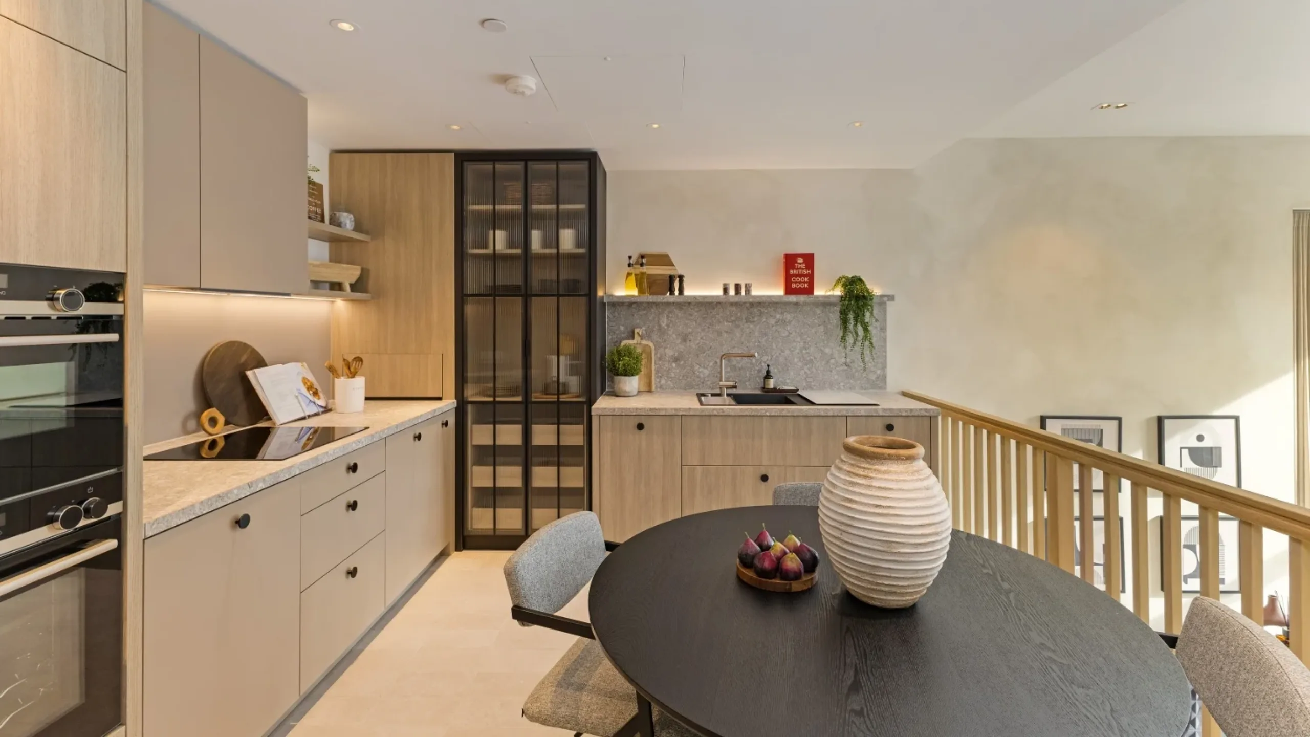 Kitchen with beige wooden cabinetry and dark brown dining table with chairs