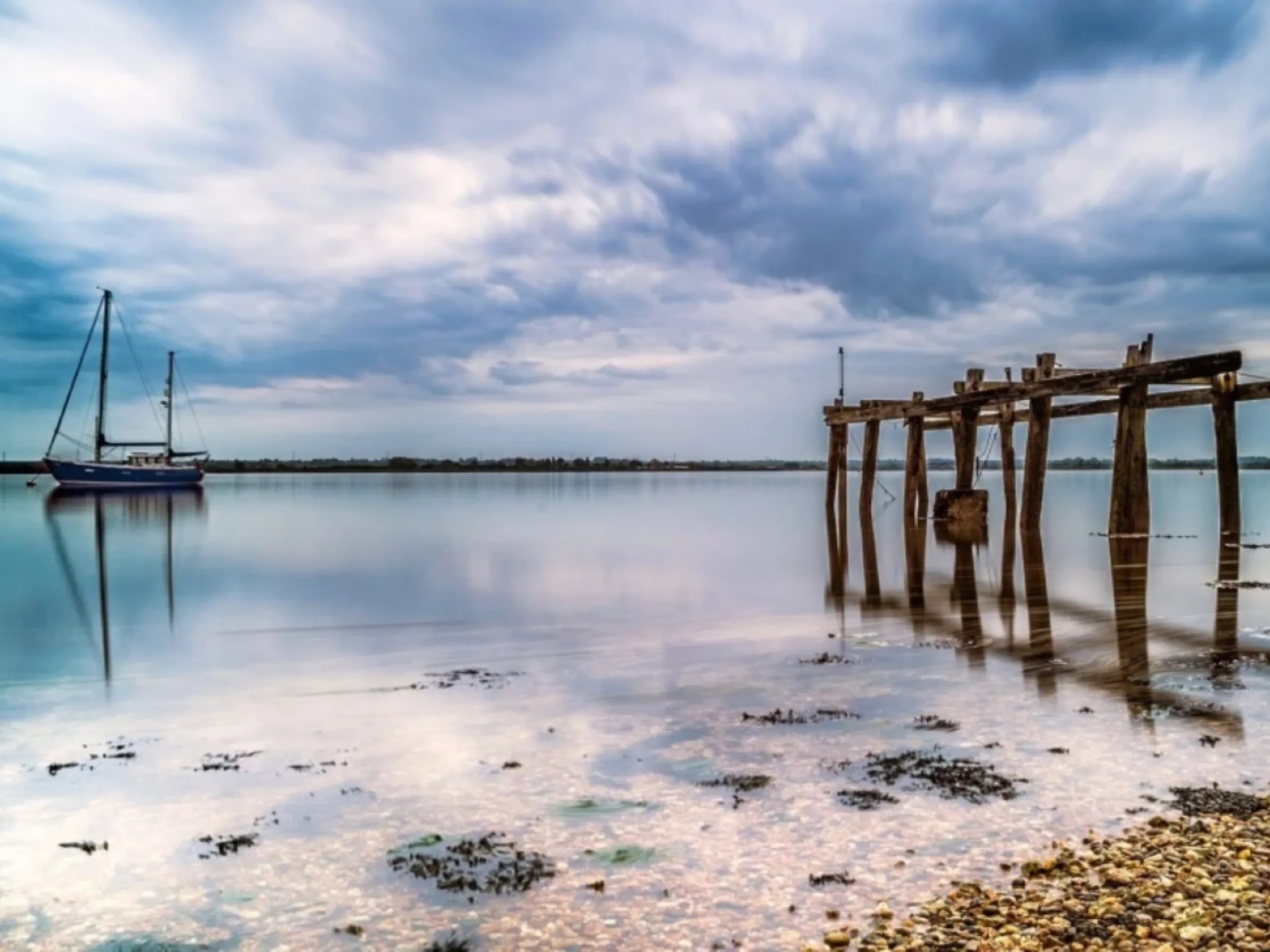 View of the blackwater estuary with a boat on the water and wooden structure on the edge