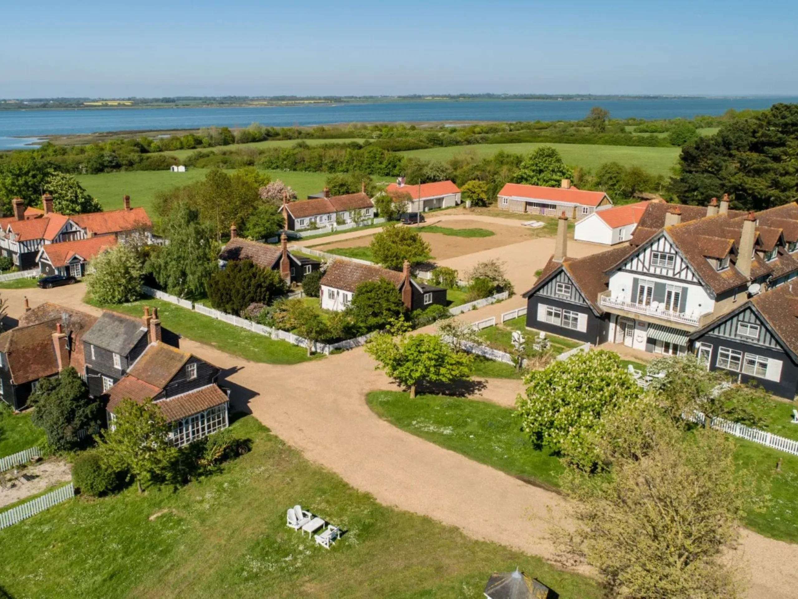 Exterior of country homes amongst green field with the estuary in the background