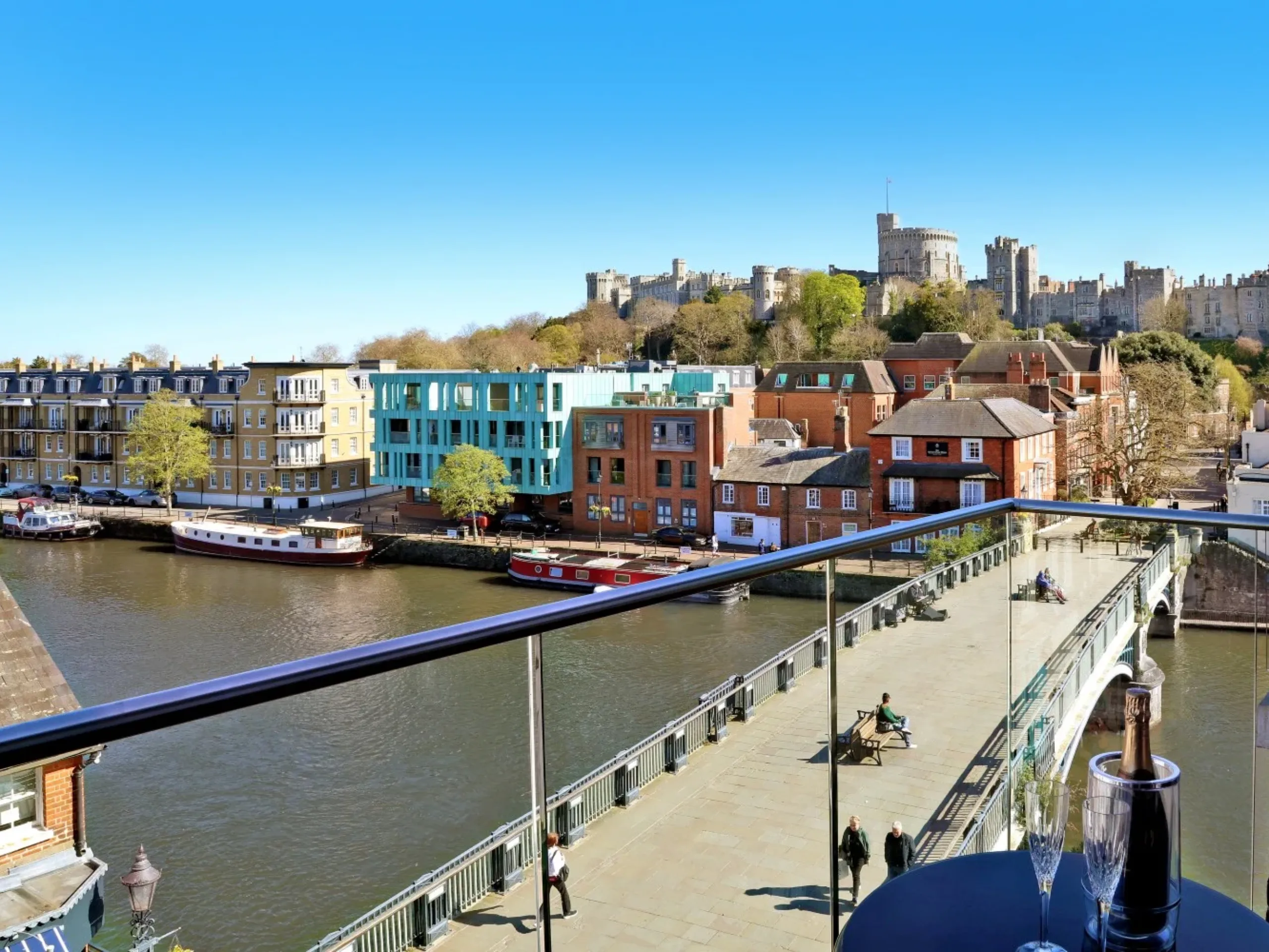 Bridge over a river with period homes, apartments and Windsor Castle in the background