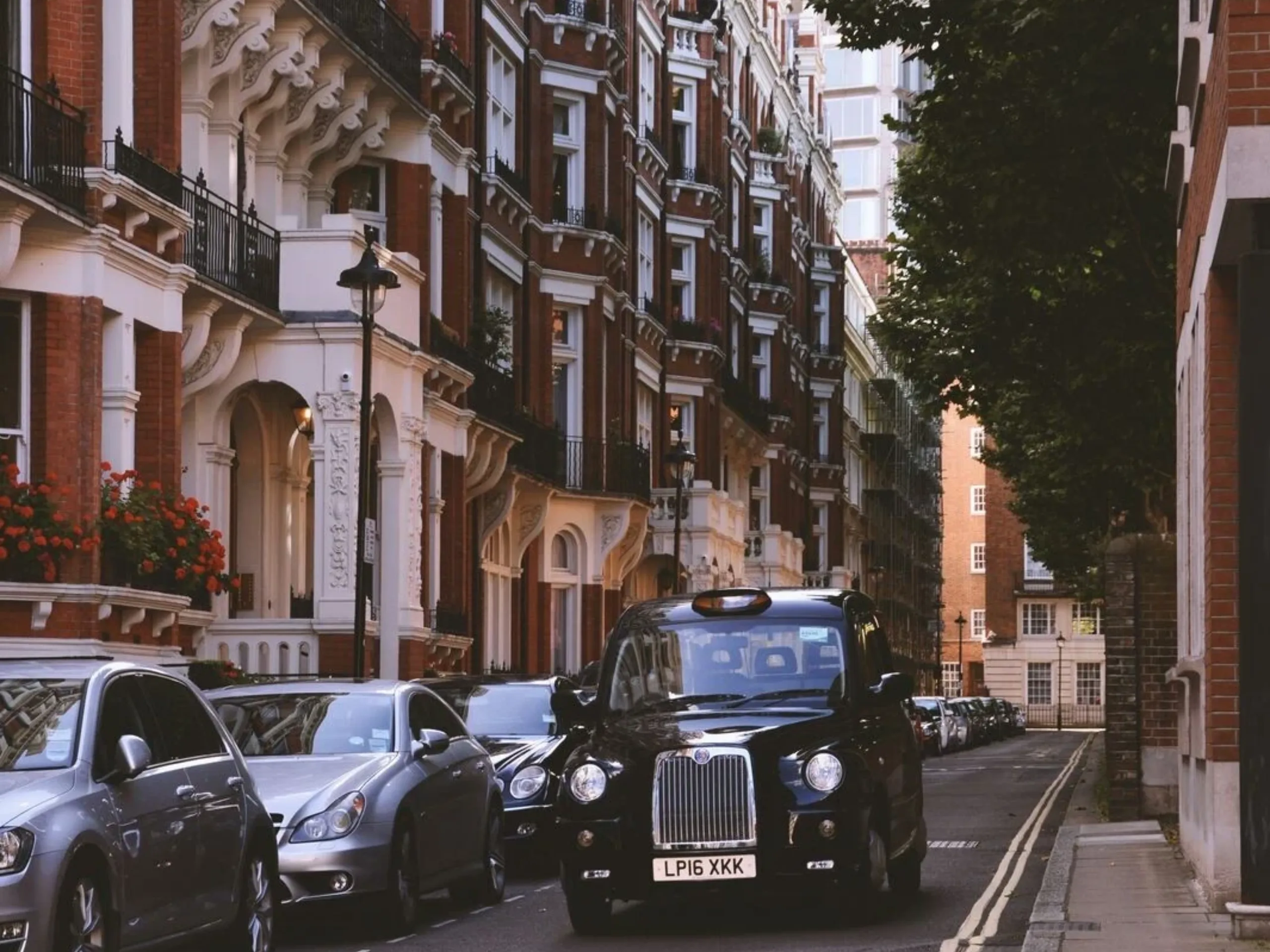 Black taxi in a street in front of period properties