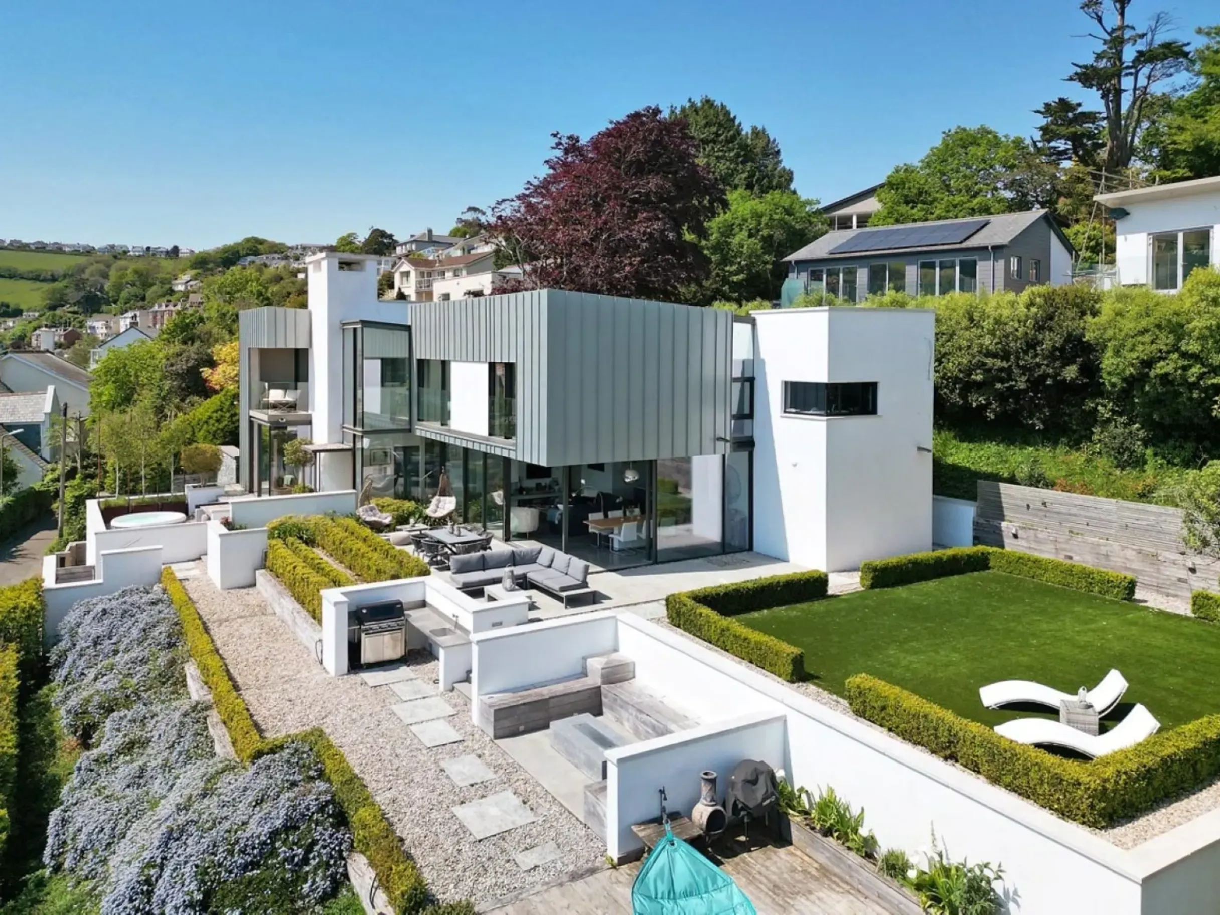 Exterior of contemporary home with a garden featuring outdoor dining and seating