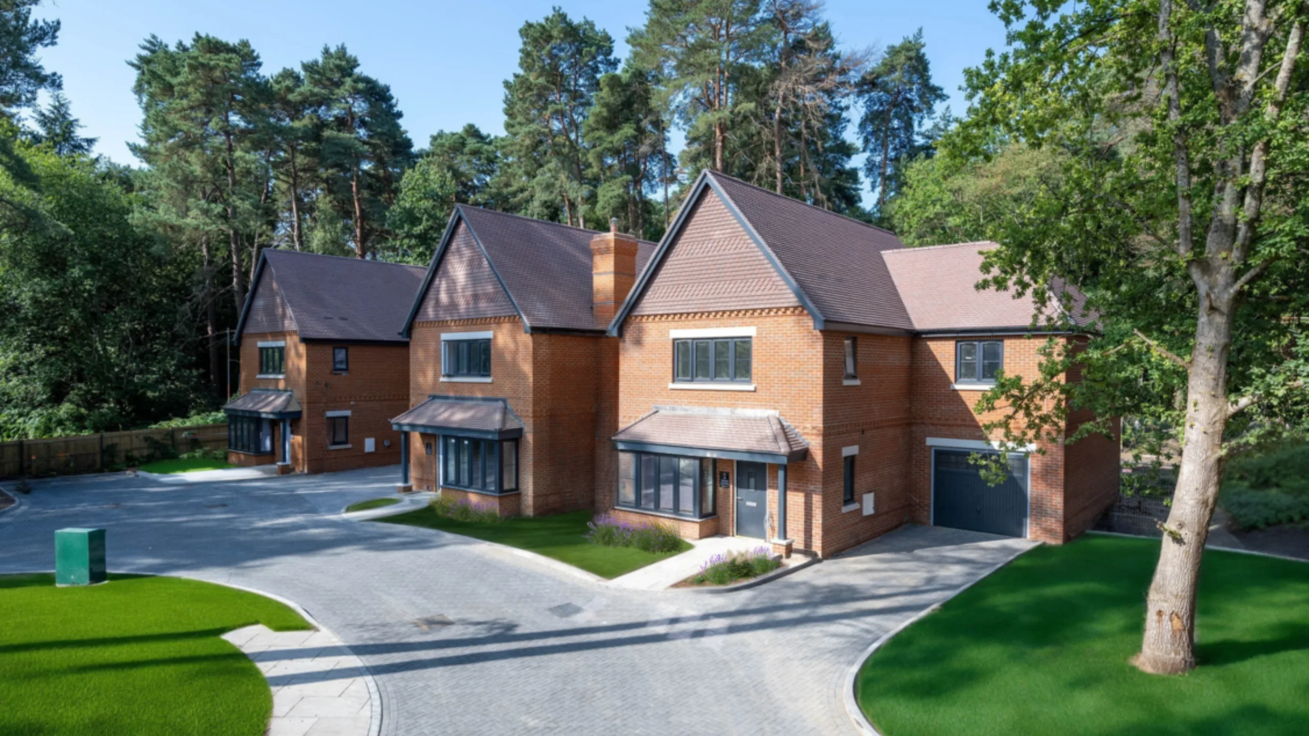 Exterior of new build detached house with a front garden and trees in the background