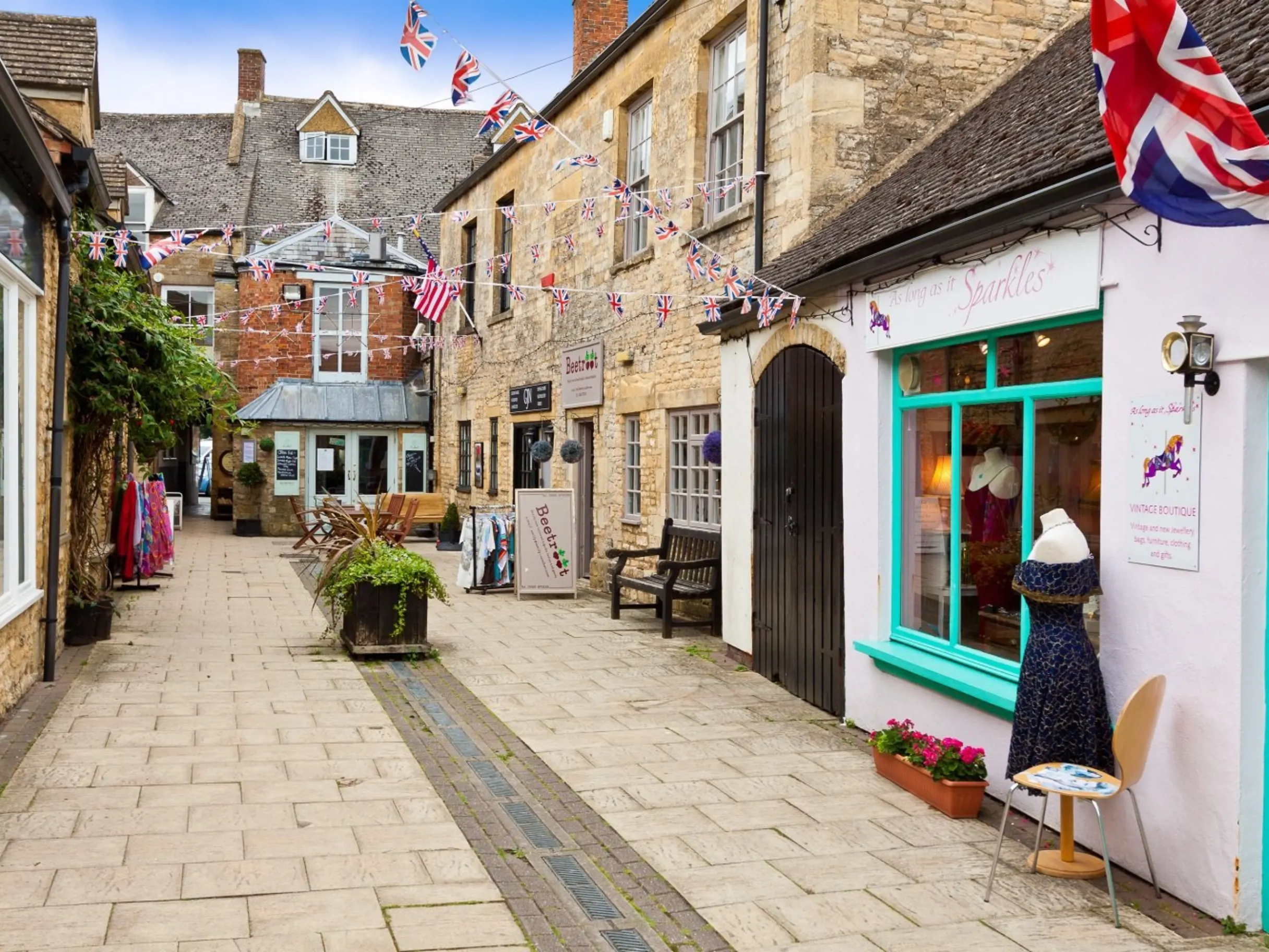 Street with union jack flags, and the exterior of independent shops