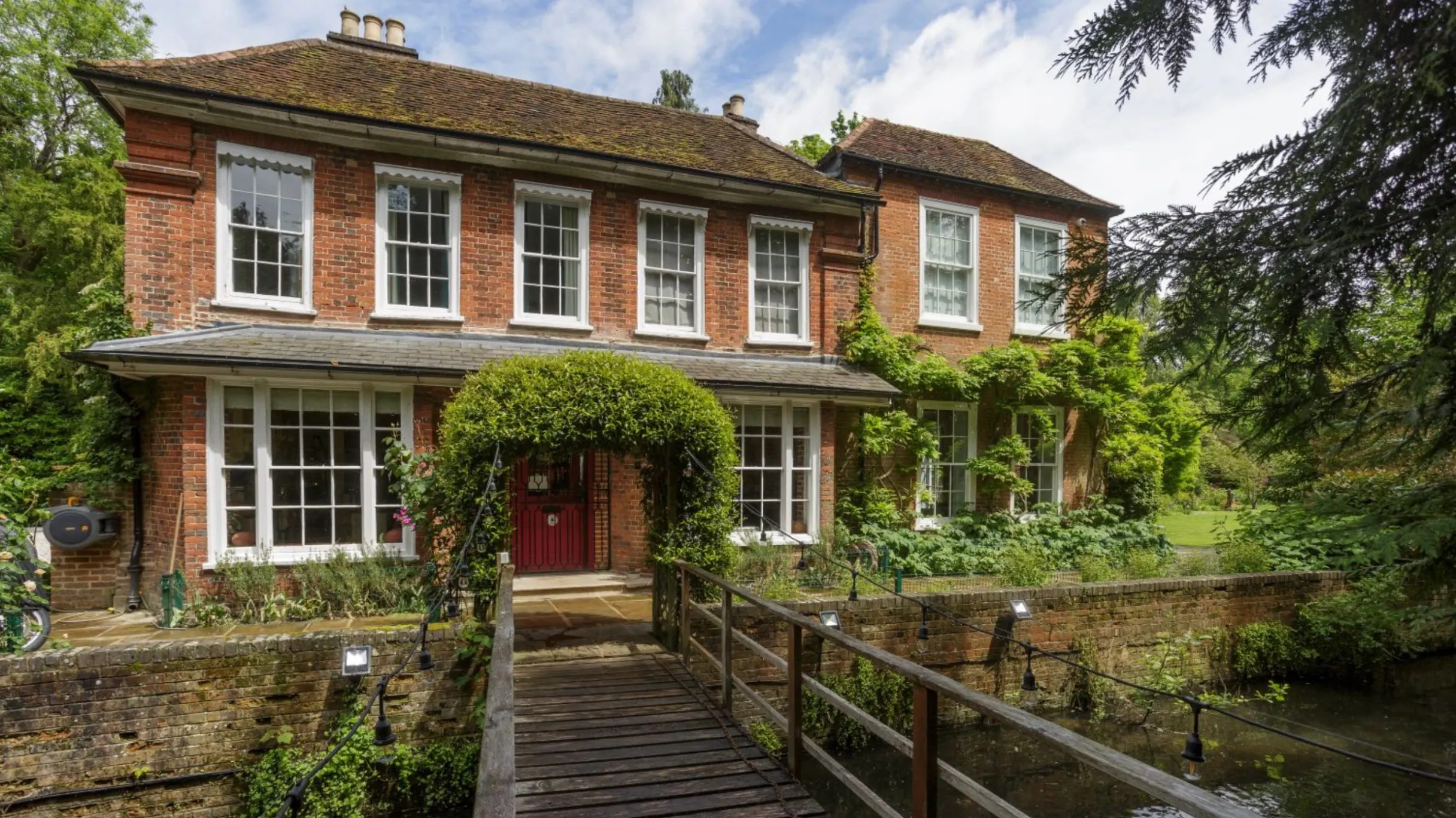 Country house exterior with bridge leading to the front over a river