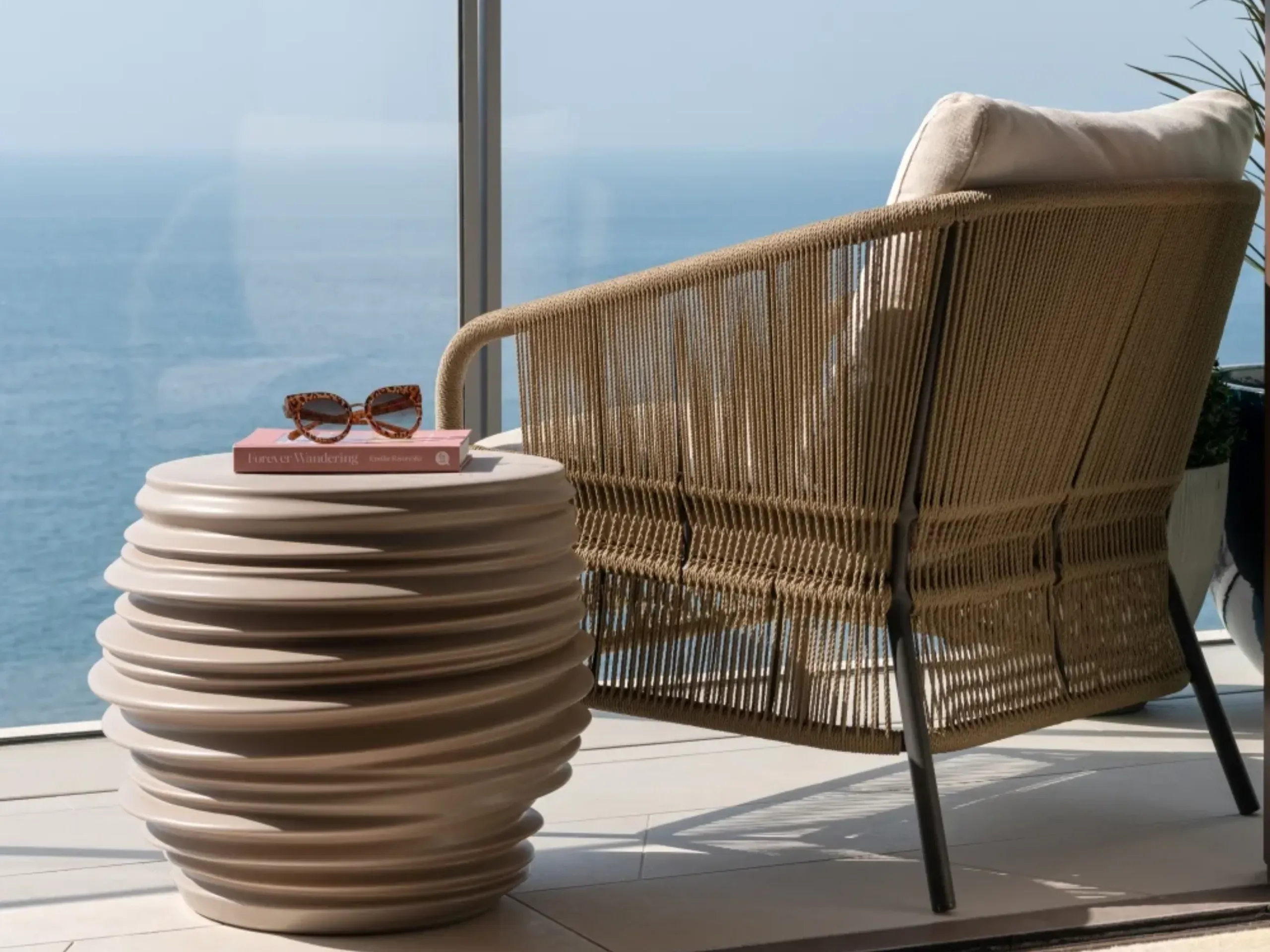 Terrace with glass screen, with an armchair and side table