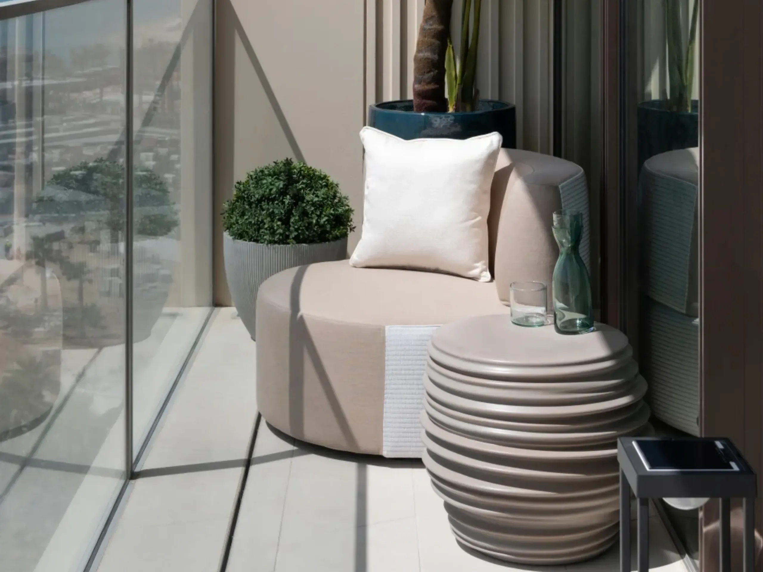 Small floating terrace with an armchair, potted plant and side table