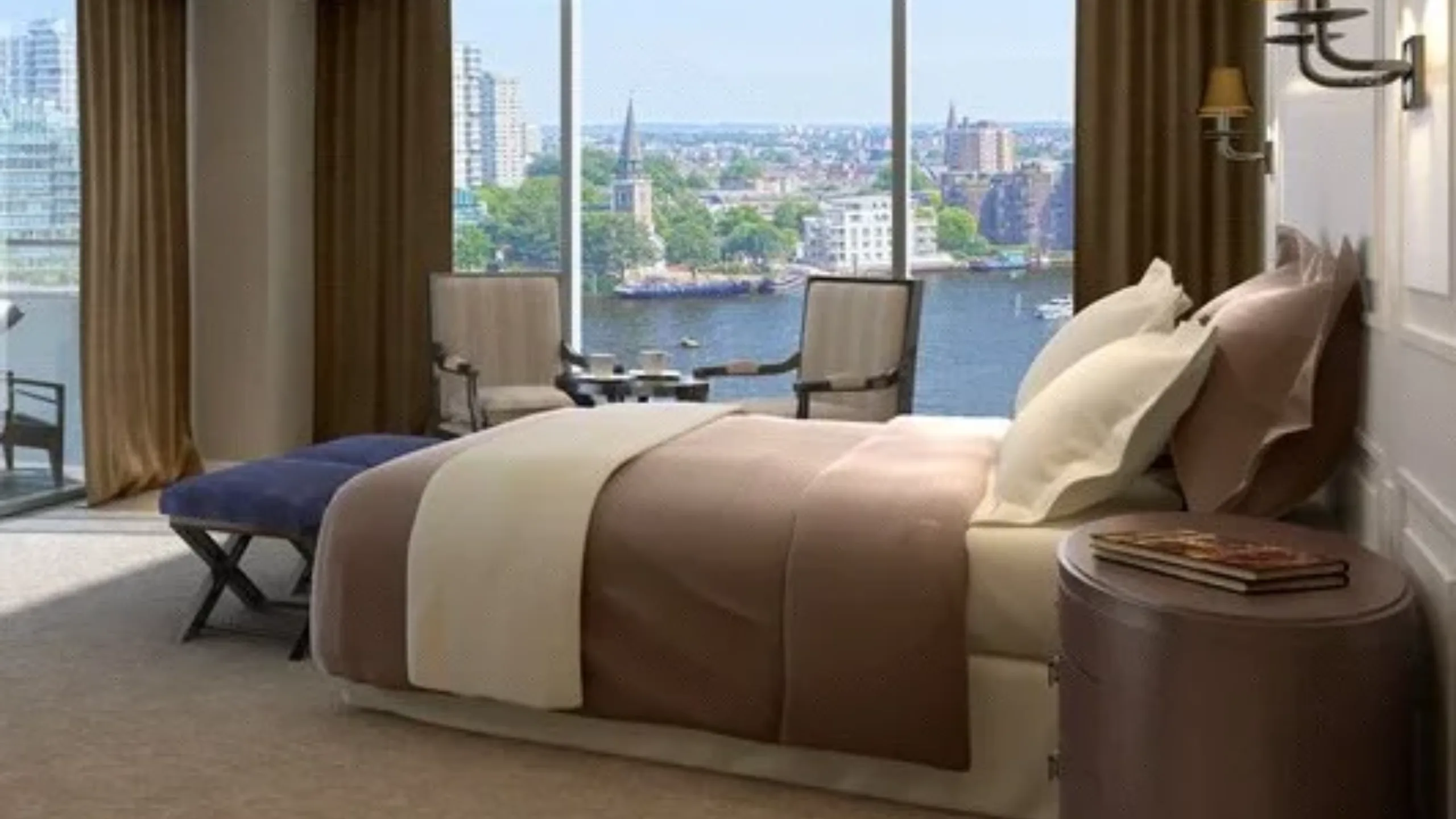 Bedroom with large bed in the middle and large windows with views of the River Thames