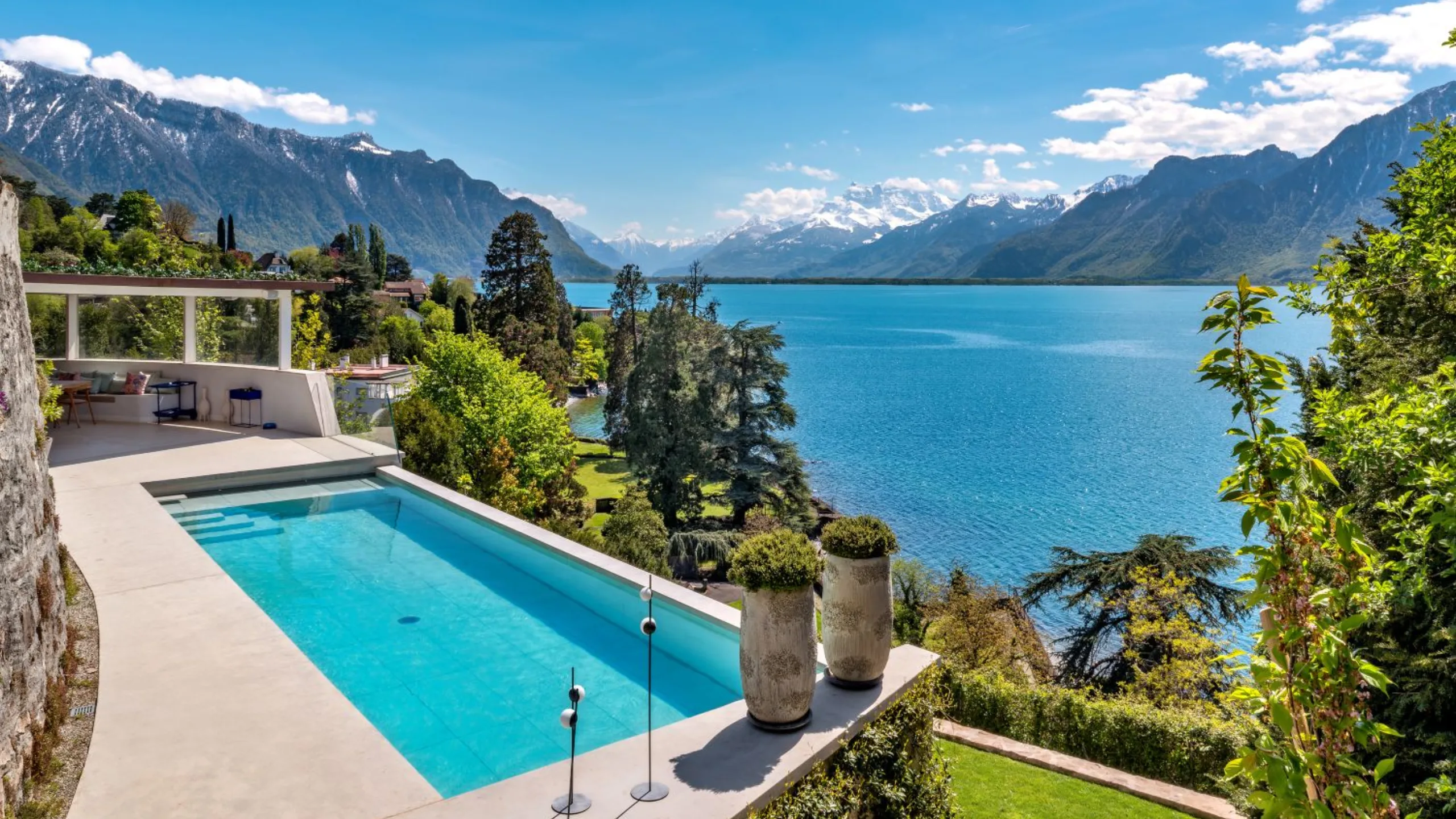 Swimming pool surrounded by trees, overlooking the sea