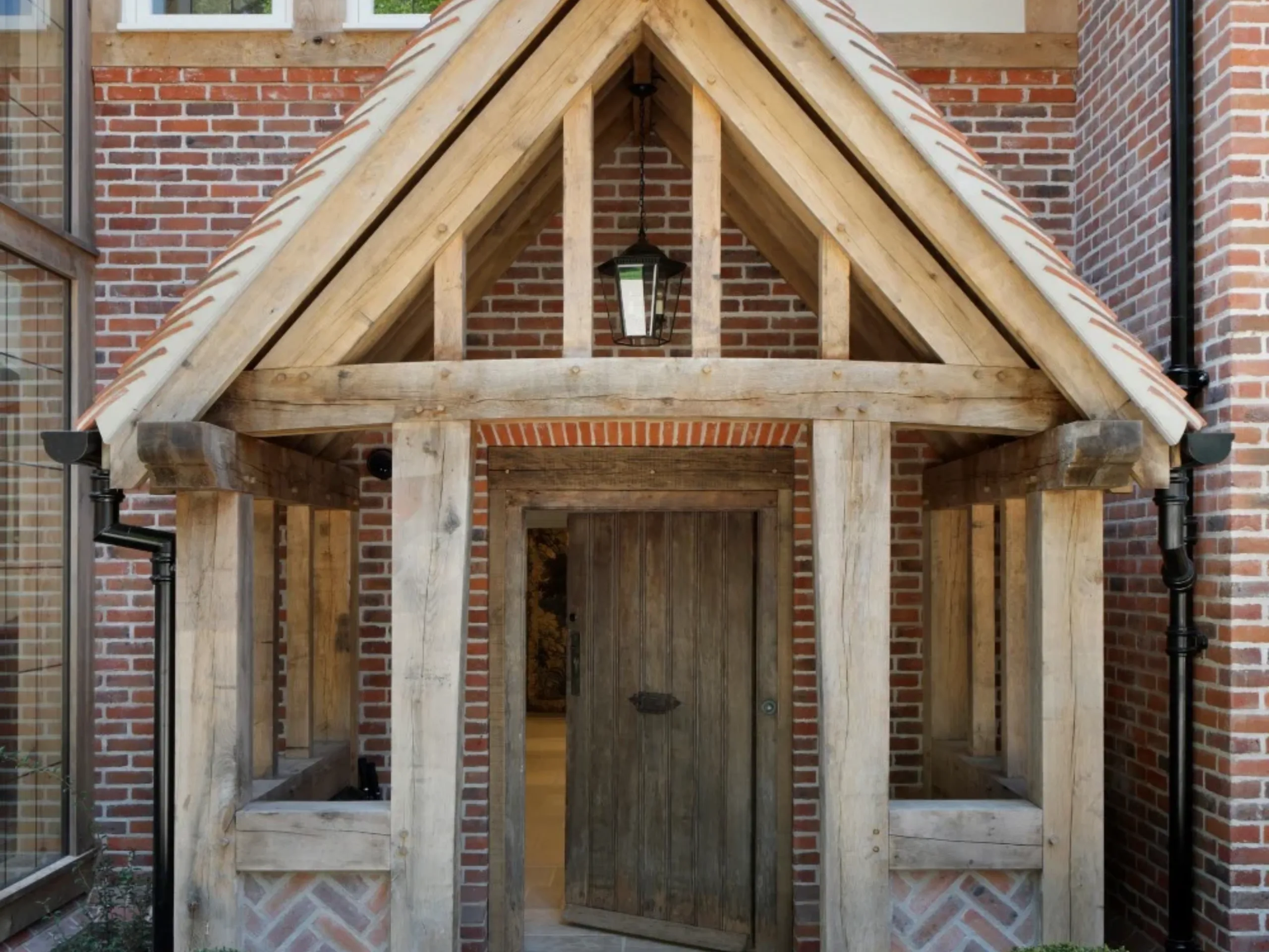 Wooden front door and porch with red brick surround
