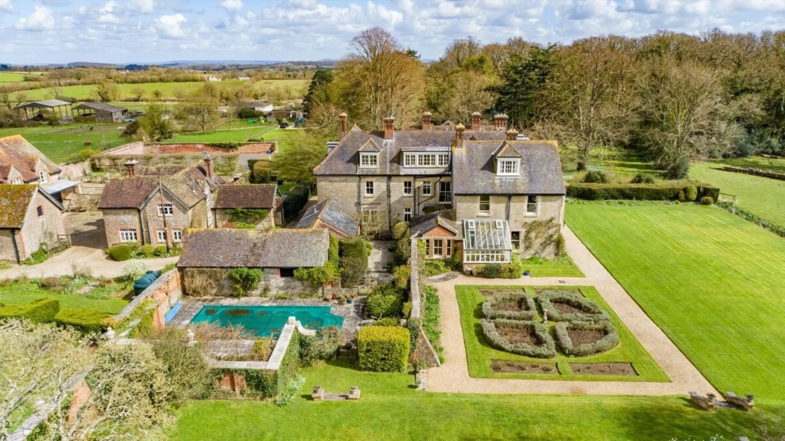 Ariel shot of large period home with expansive gardens and swimming pool