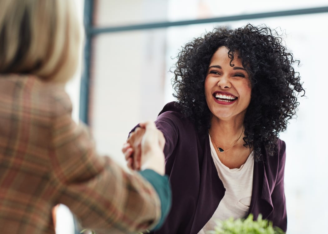 A woman shaking hands with her colleague