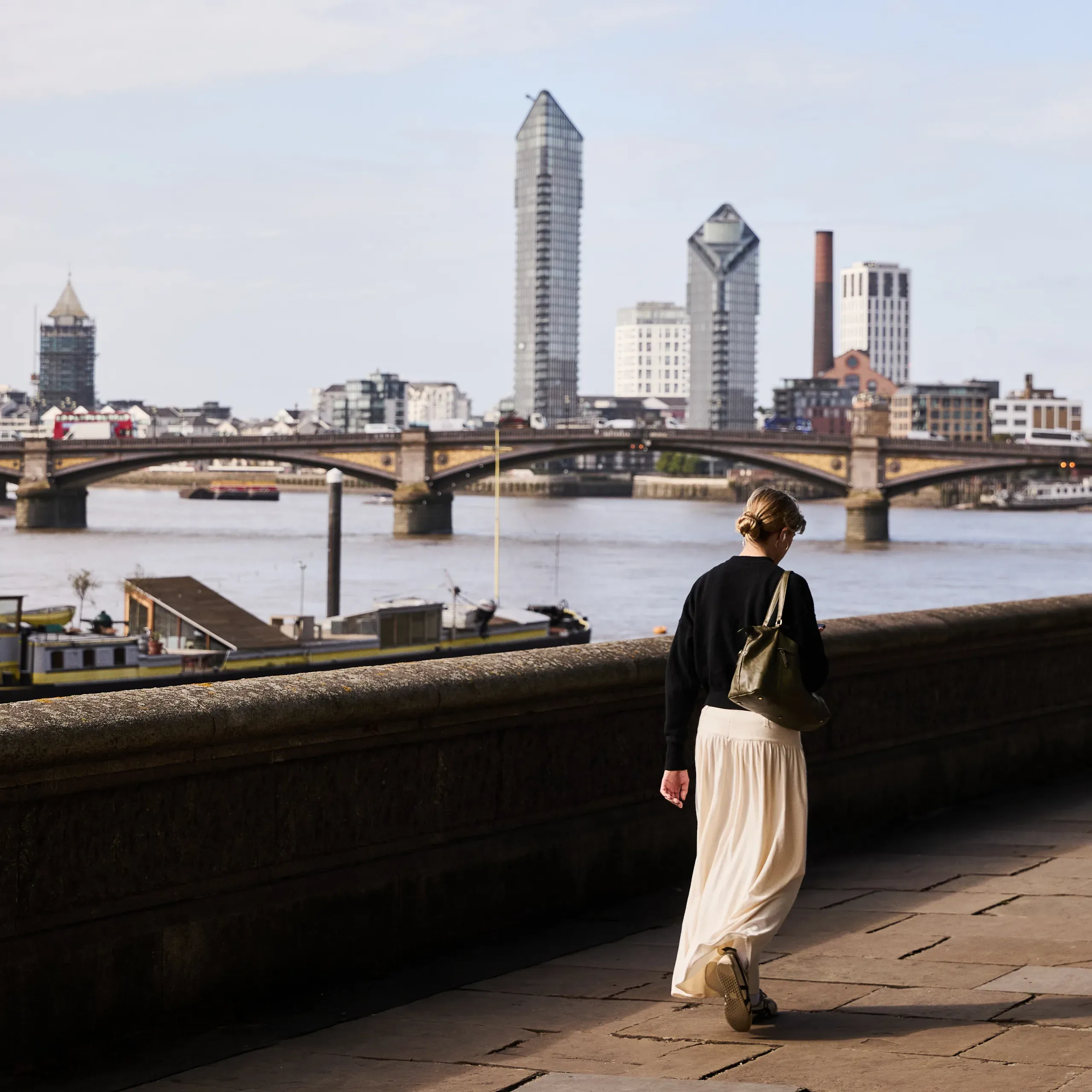 Woman walking along the River Thames, London