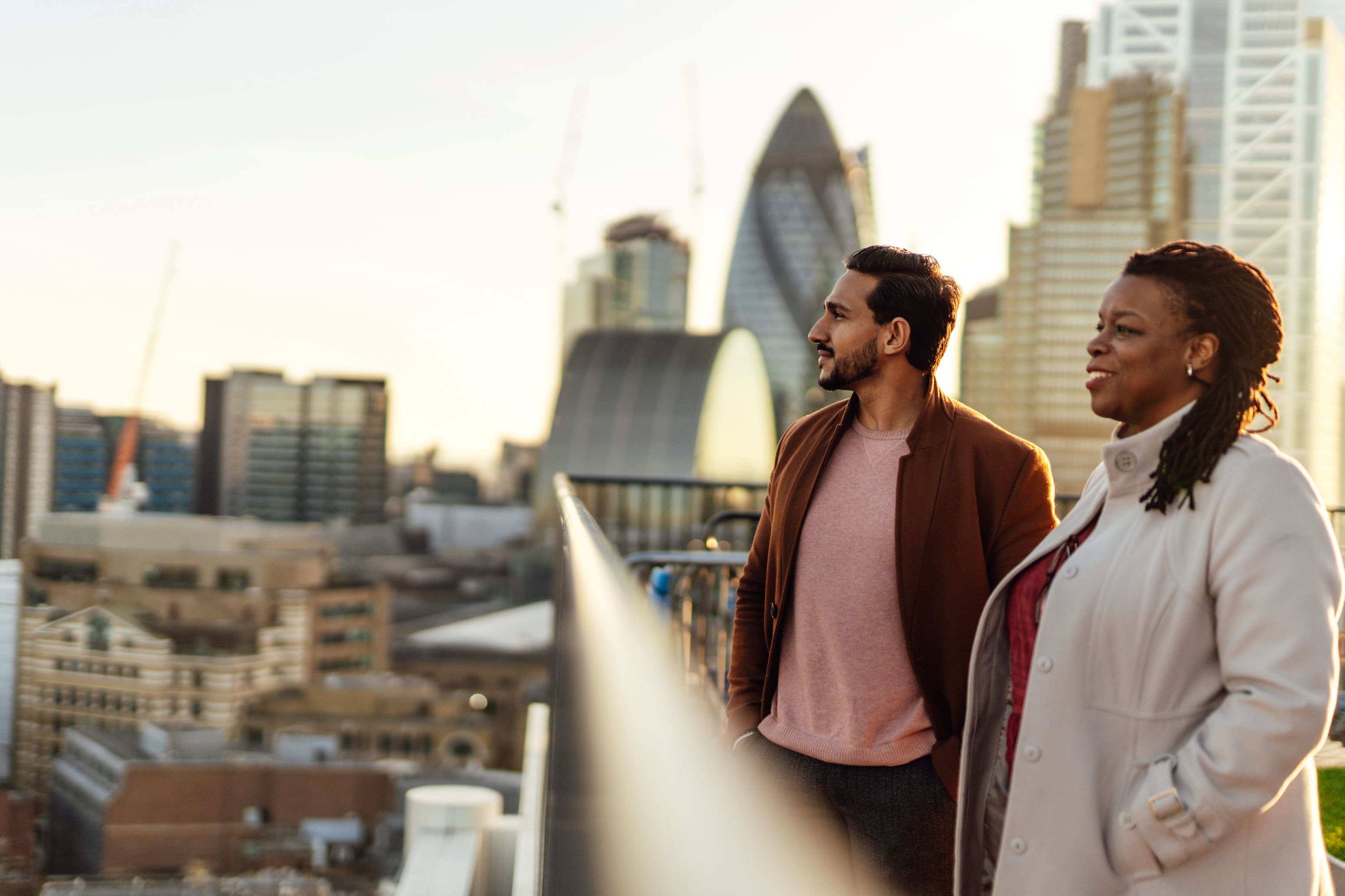 Two people on an office balcony looking at the London skyline