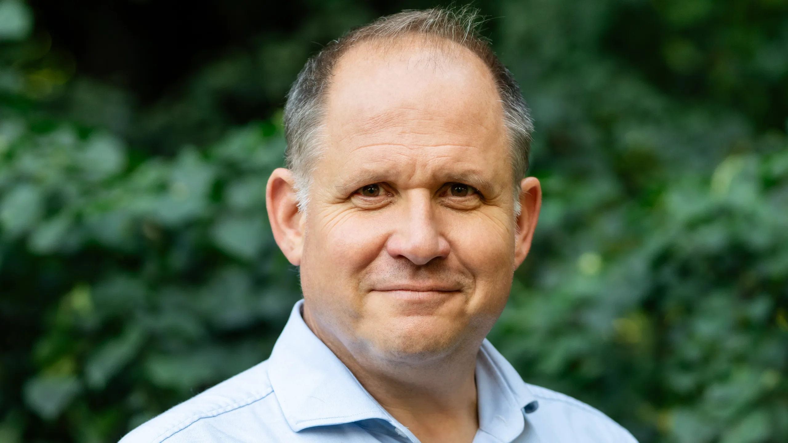 Henry Dimbleby in a blue shirt staring directly into the camera