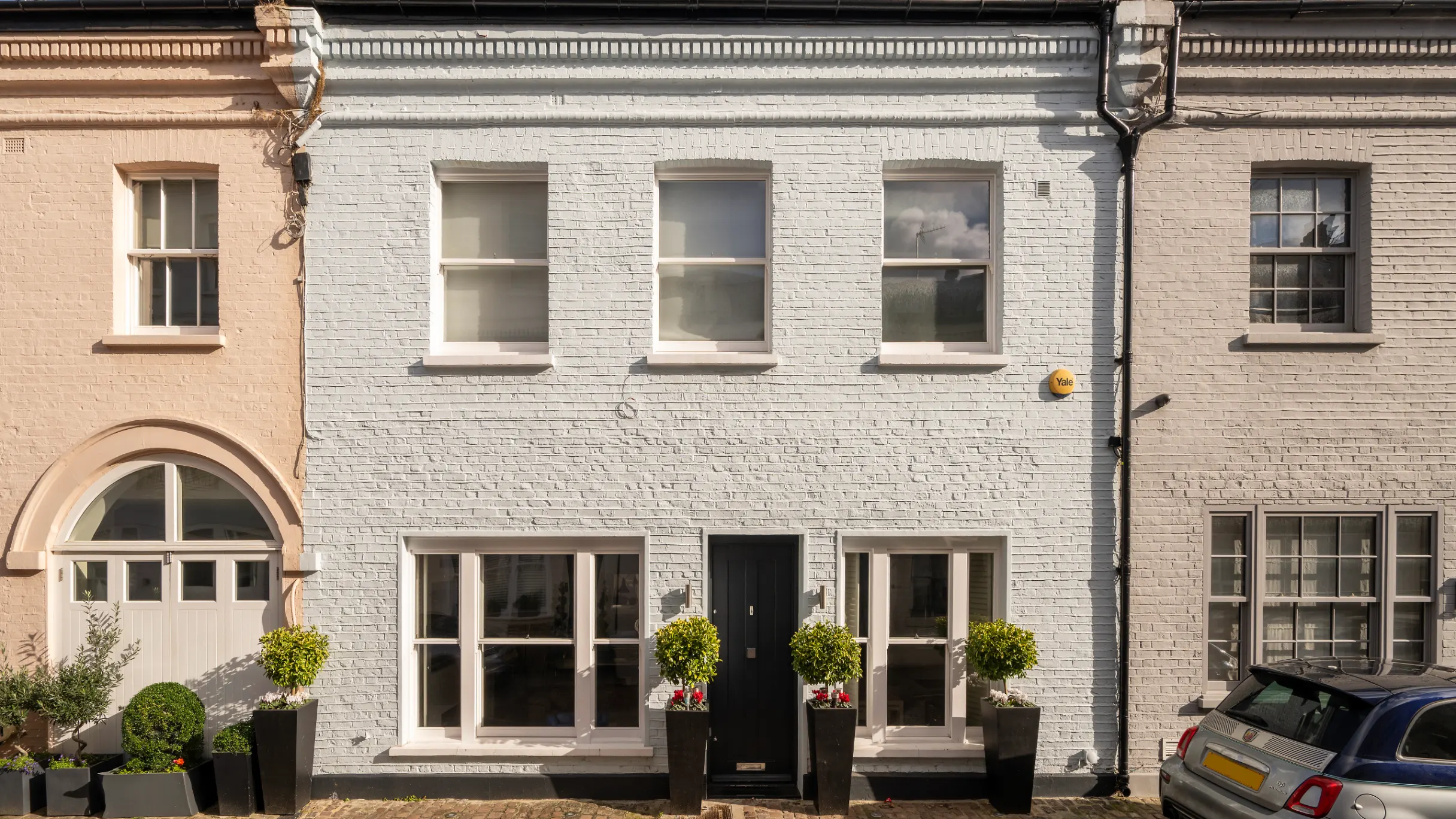 Exterior of a row of mews houses with flower boxes in front 