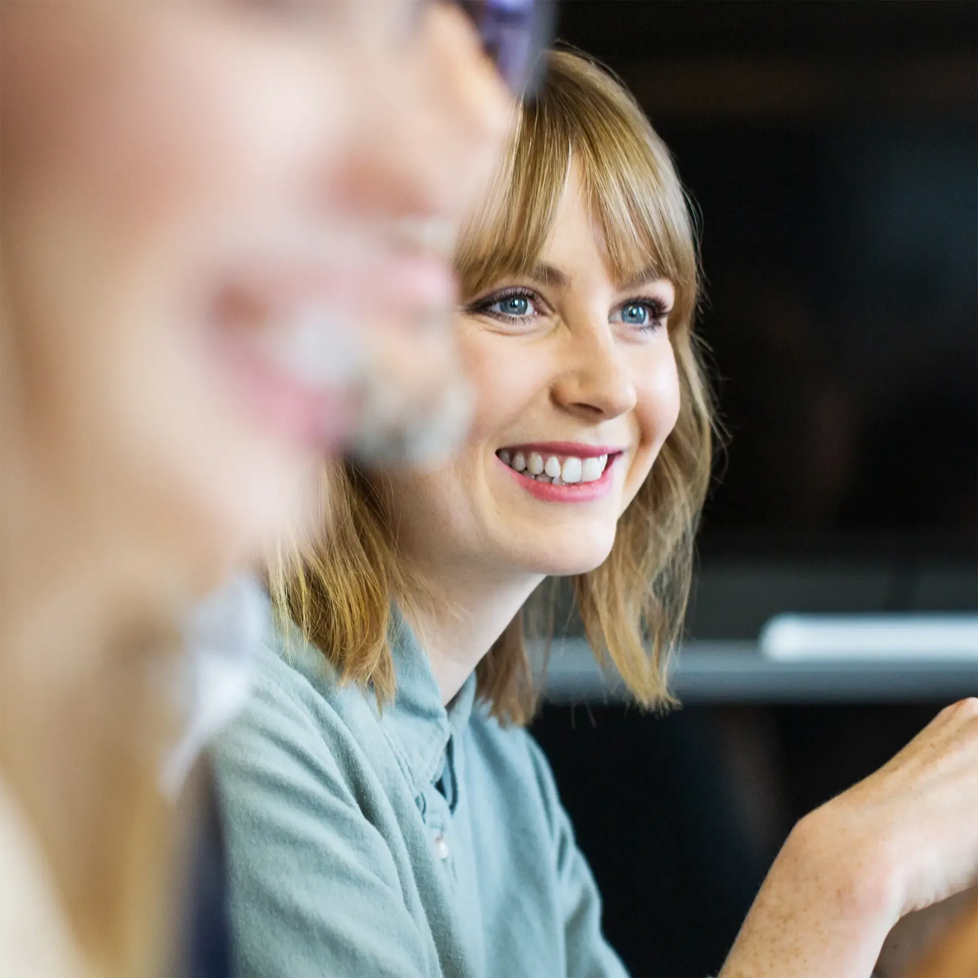 Young businesswoman sitting in meeting and listening to conversation. Female professional listening to colleague in meeting.