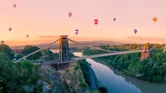 Hot air balloons over Clifton Suspension Bridge at sunrise, England