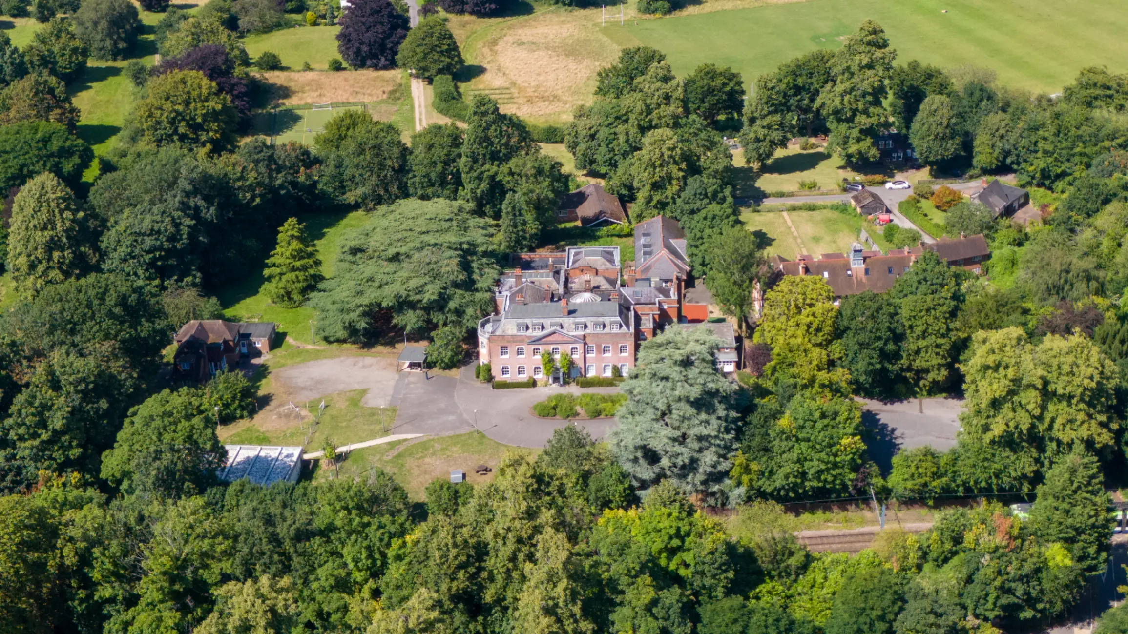 Aerial photo of an educational institution surrounded by green fields and trees