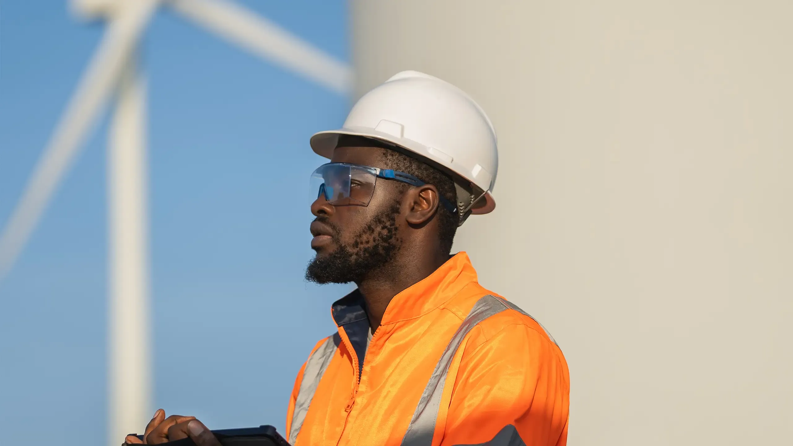 Engineer man using tablet for wind turbine sustainable energy generator project.