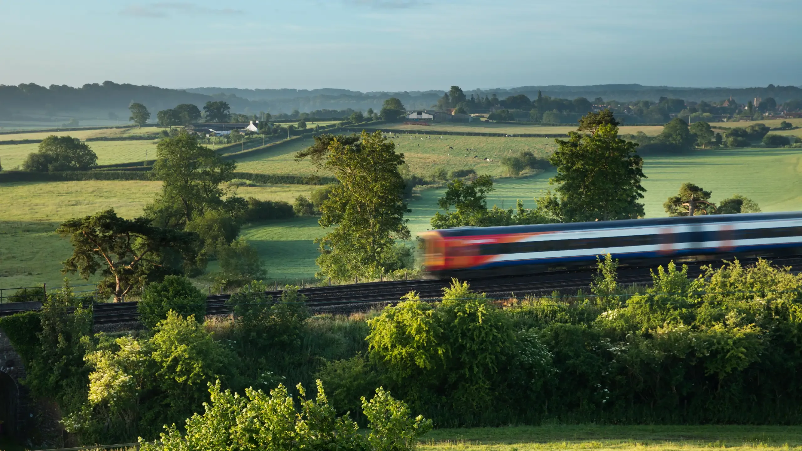 the London Waterloo to Exeter train passing Milborne Wick on a misty summer's morning, Somerset, England, UK