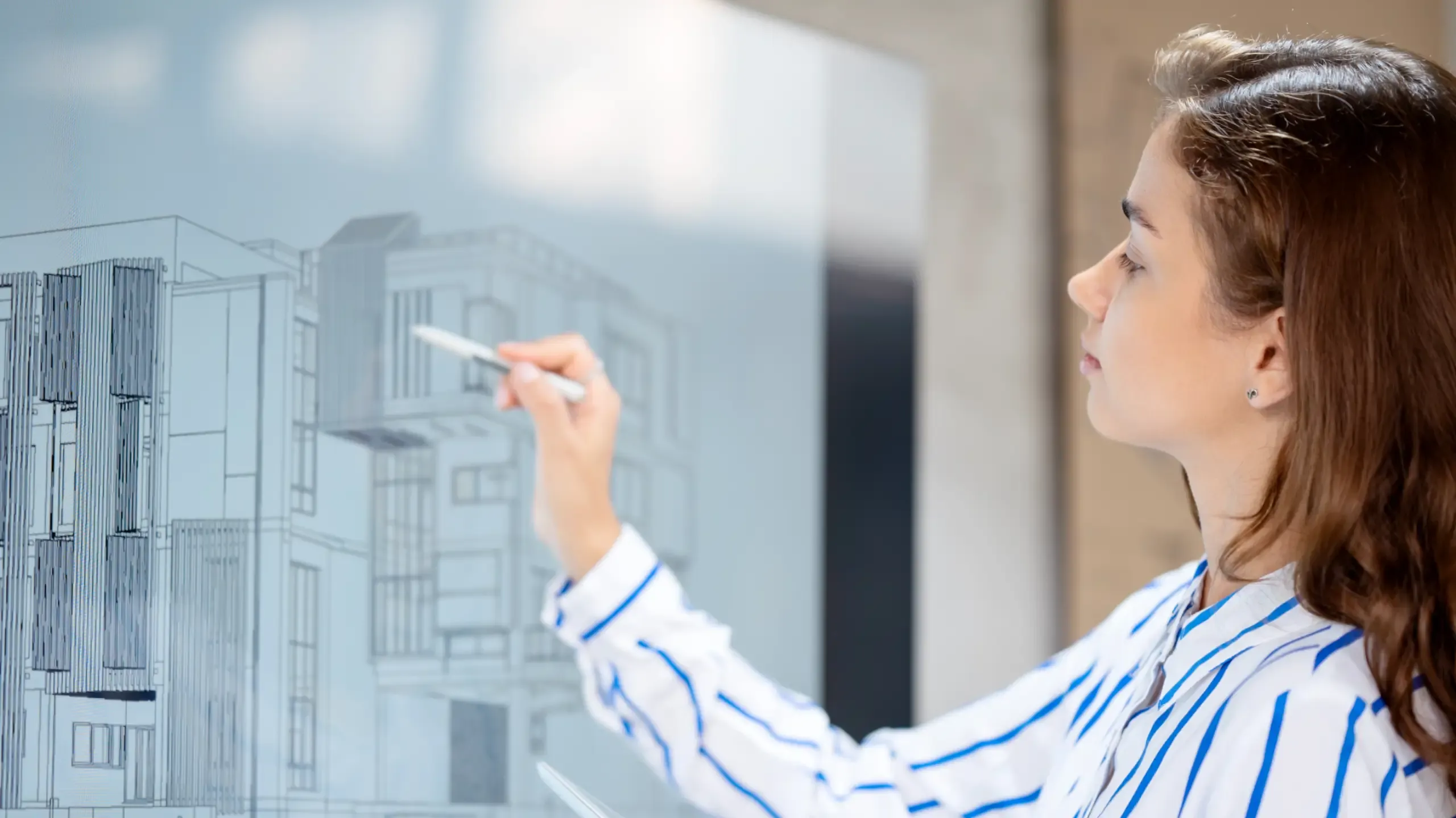 A female architect is drawing on a whiteboard as part of a real estate construction project.