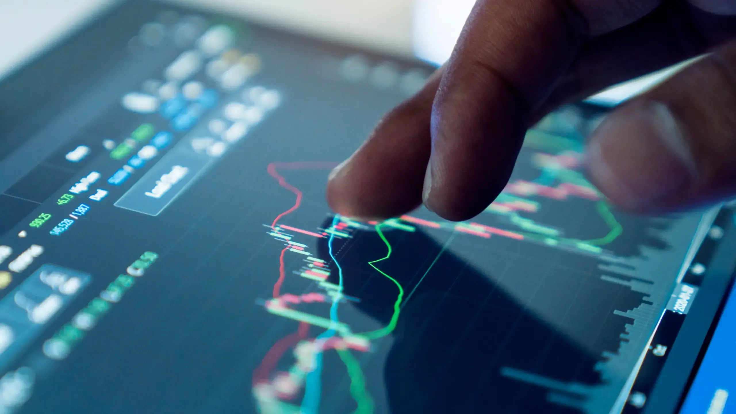 Market analyse with digital monitor focus on tip of finger