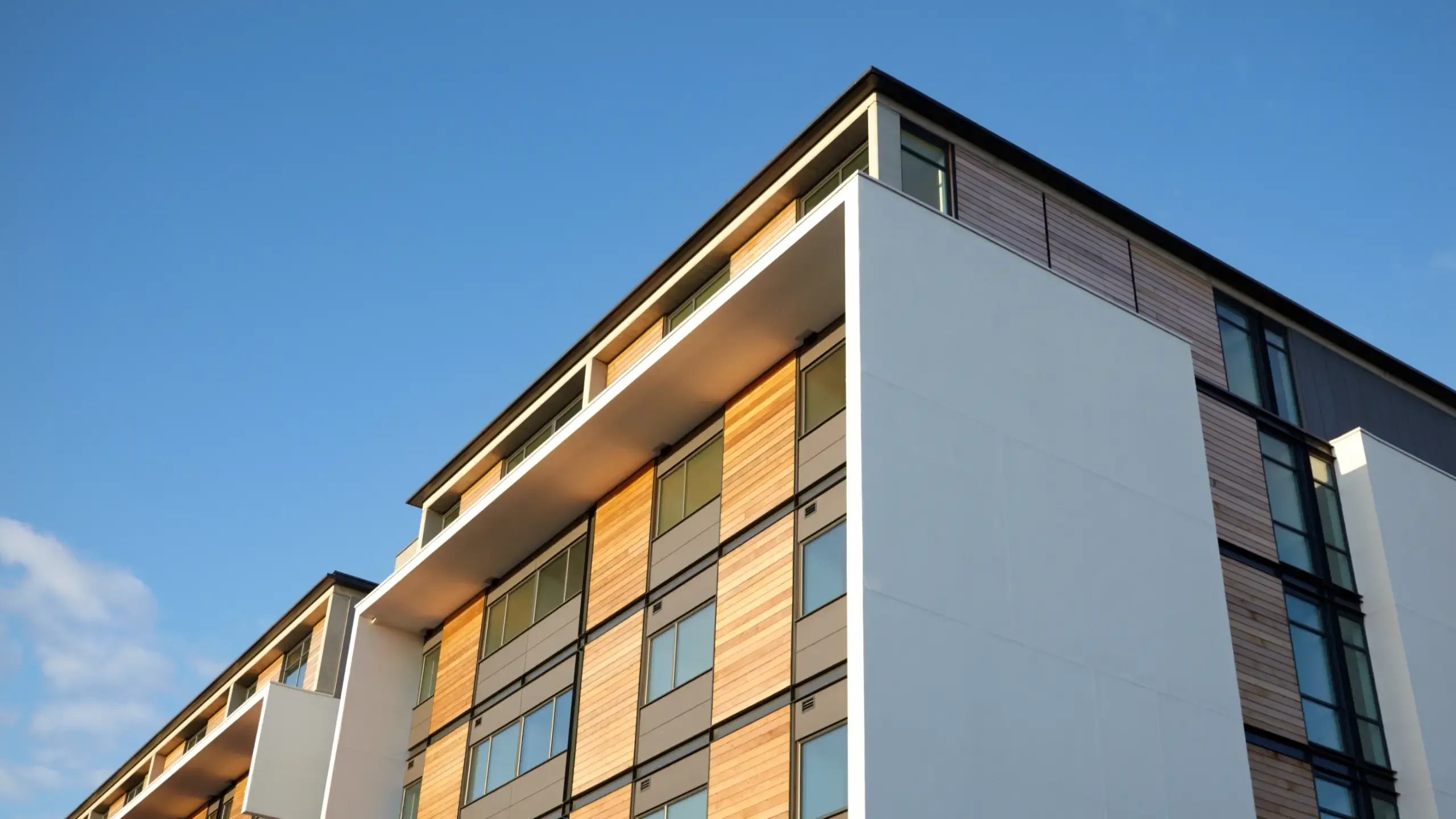 Residential apartment with wood panels and blue clear sky - Salford Quays, Salford, Manchester, England, UK