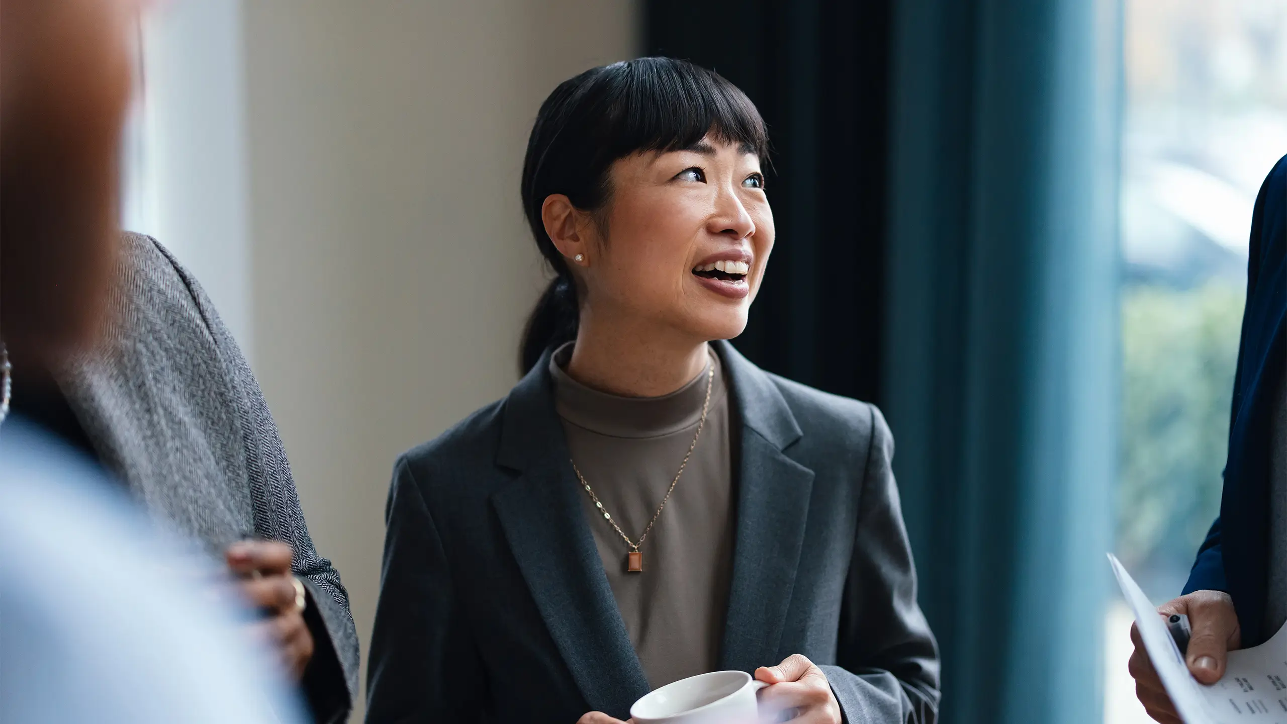 Team of four multi-ethnic employees talking about business strategy while drinking coffee together.