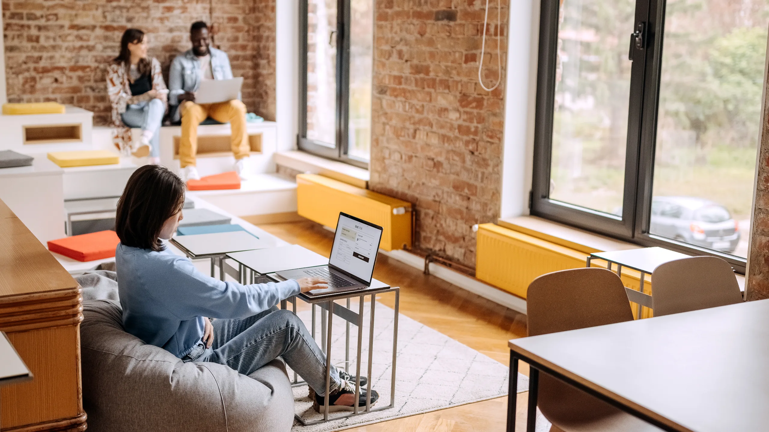 Young casually clothed woman shopping online for clothes in office cafeteria