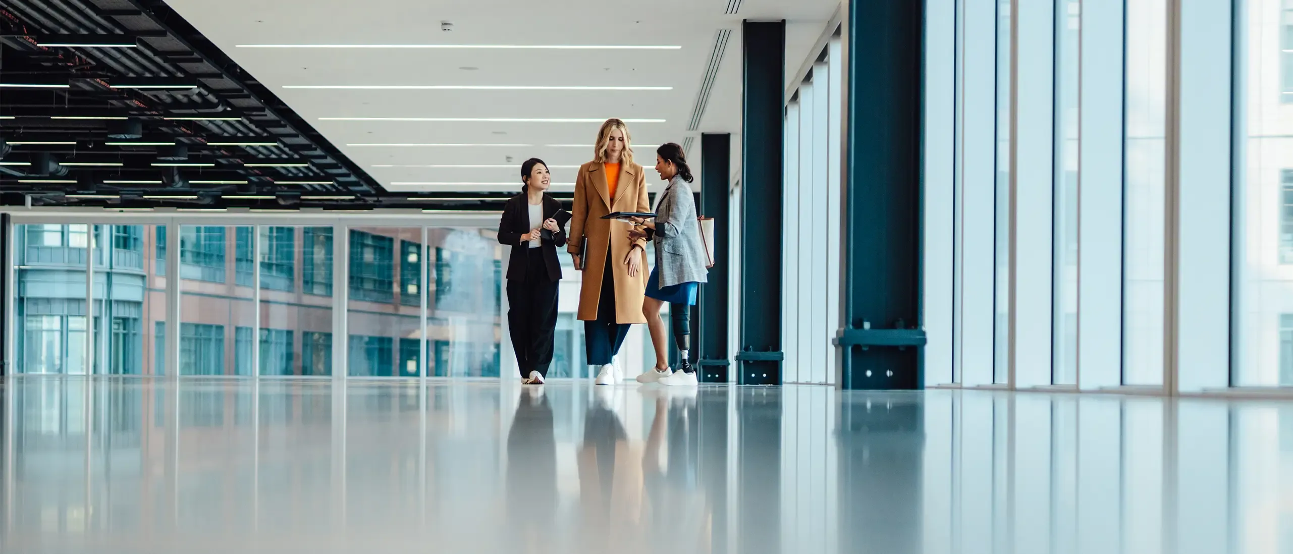 Multi racial group of businesswomen viewing new office space with an estate agent