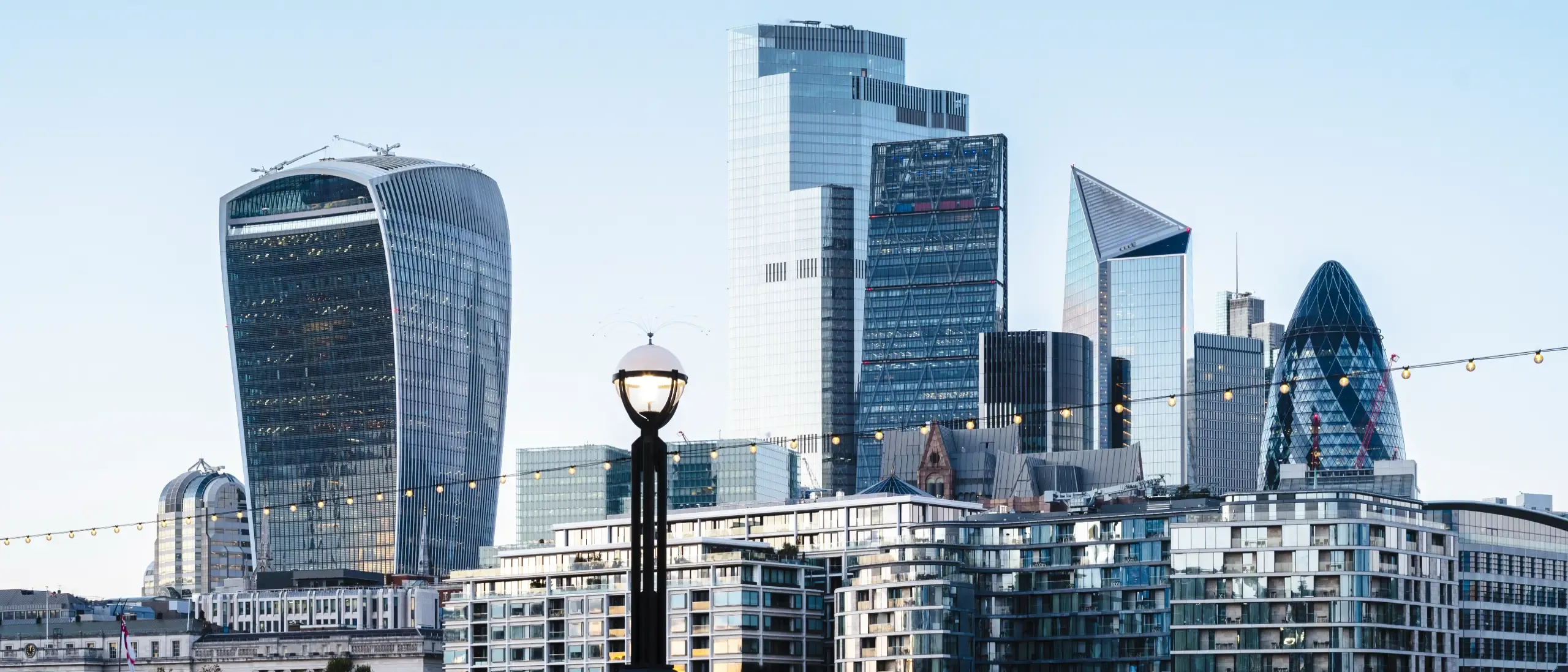 View towards the skyline of the City of London from the Thames Path at dusk