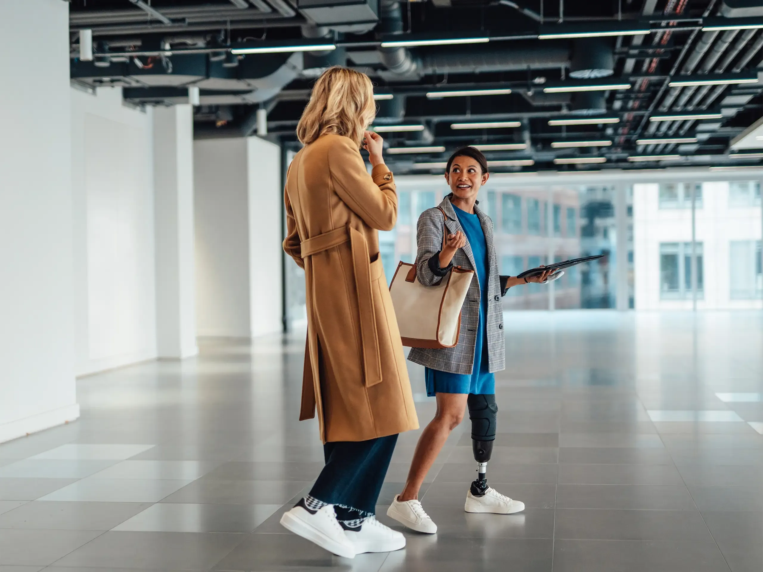 A young female businesswoman is being shown around some modern office space by a commercial real estate agent. Diversity, Equity and Inclusion in the workplace.