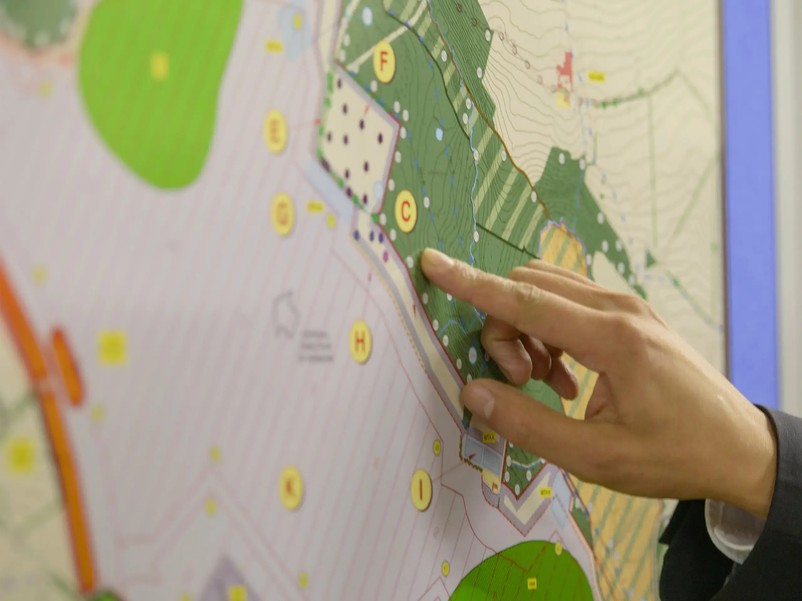 Member of public pointing at map of proposed planning inquiry in town hall