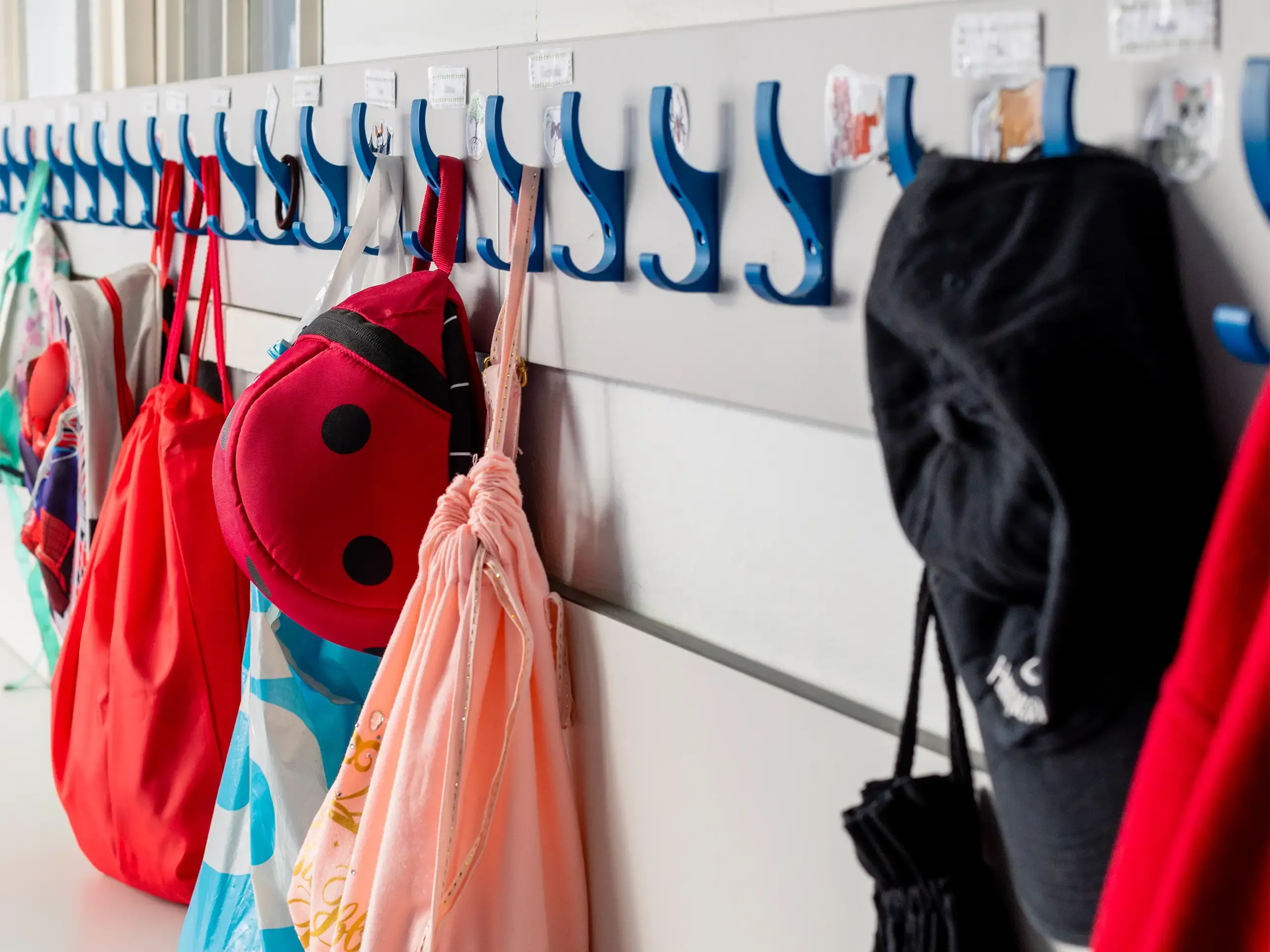 Coats and bags hung up on pegs in a primary school in the North East of England.