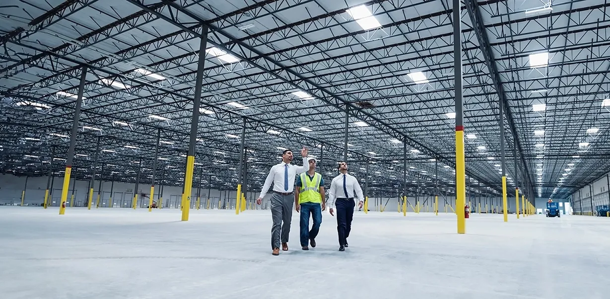 Businessmen walking and talking in empty warehouse