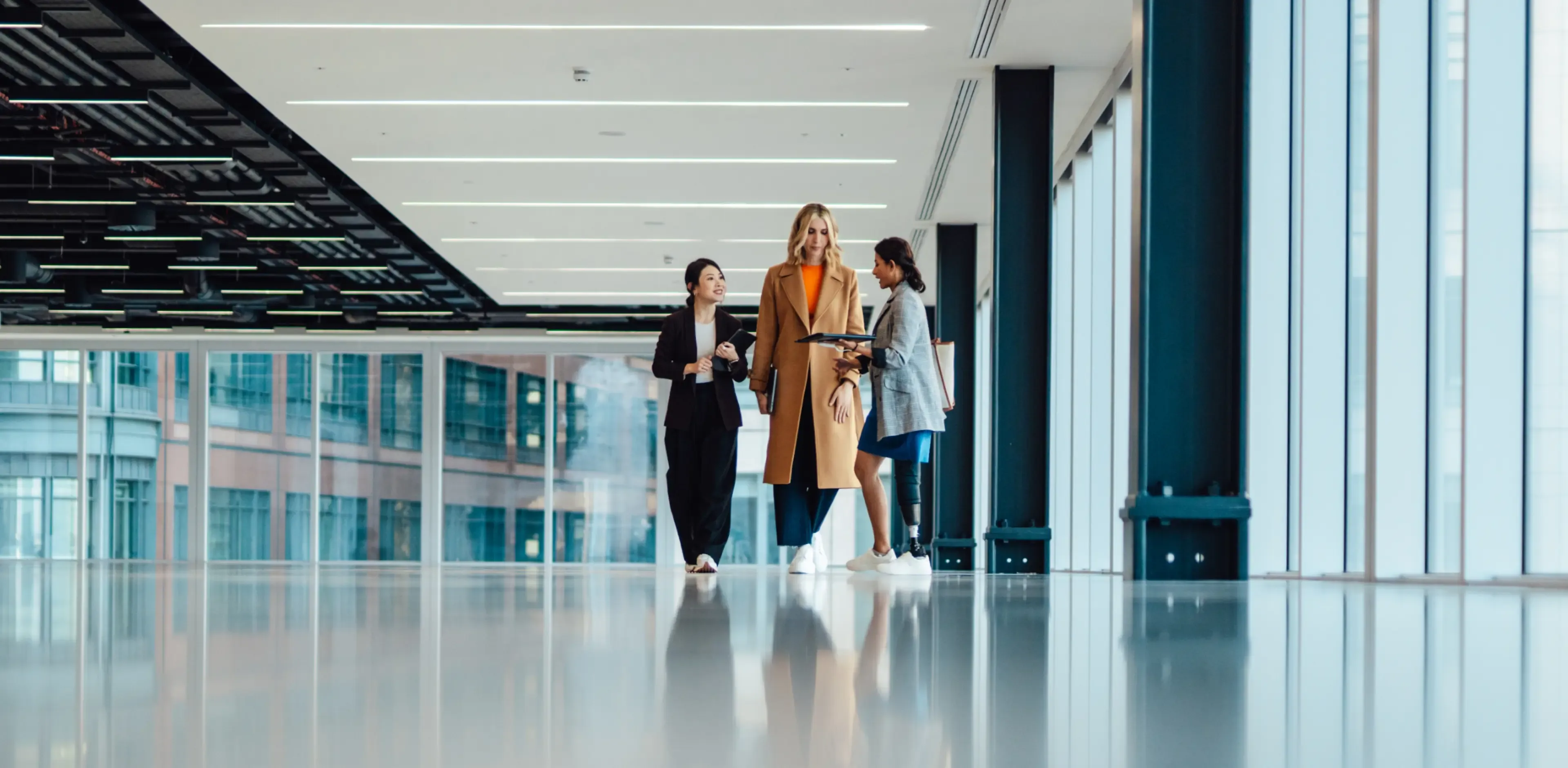 Multi racial group of businesswomen viewing new office space with an estate agent