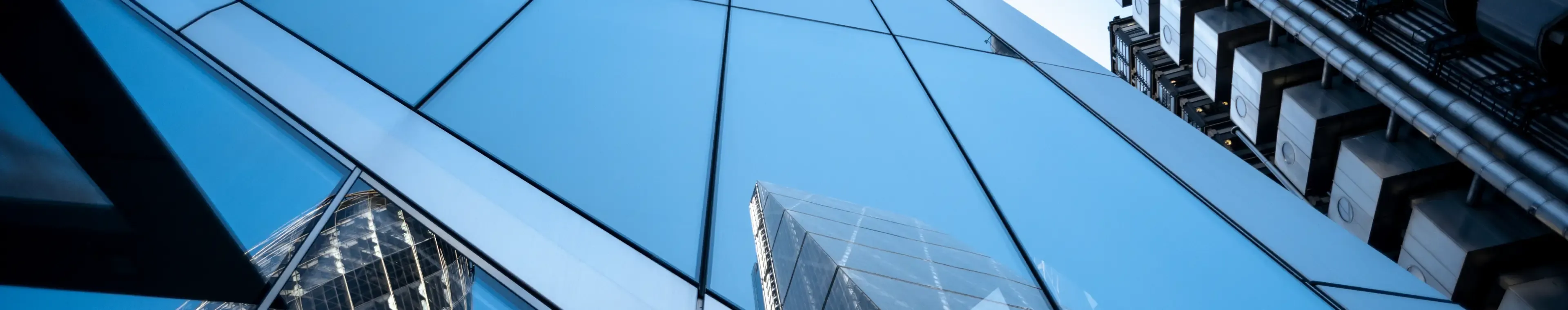 UK, London, reflection of office buildings in the financial district against clear sky