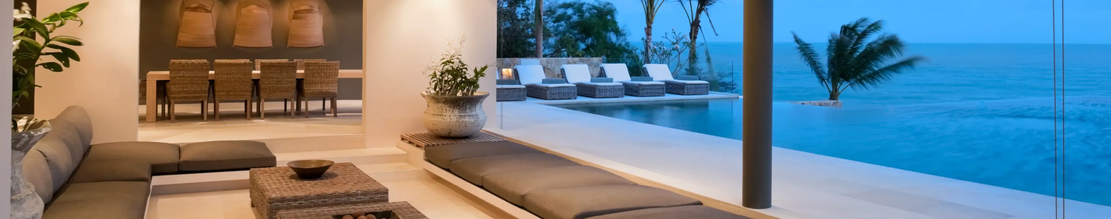 Luxury island villa with infinity pool at sunset with view out to sea.