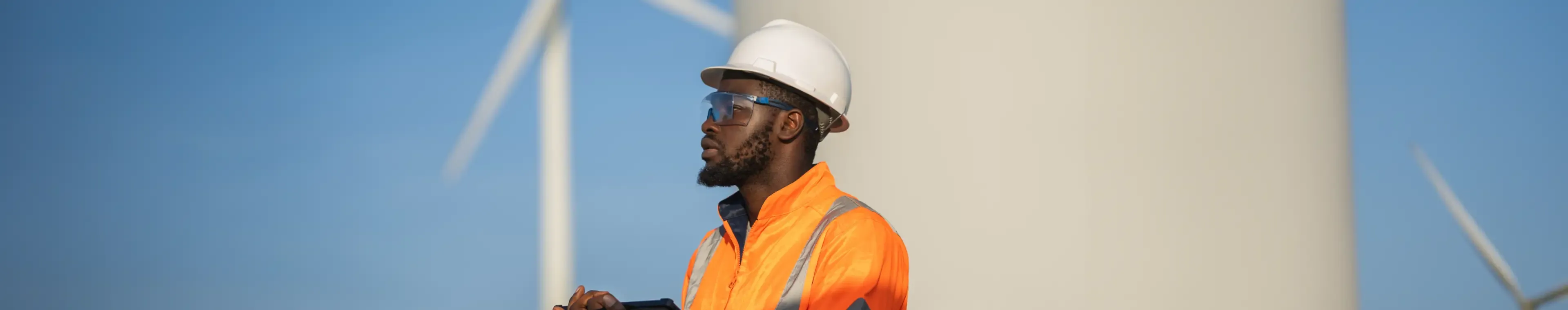 Engineer man using tablet for wind turbine sustainable energy generator project.