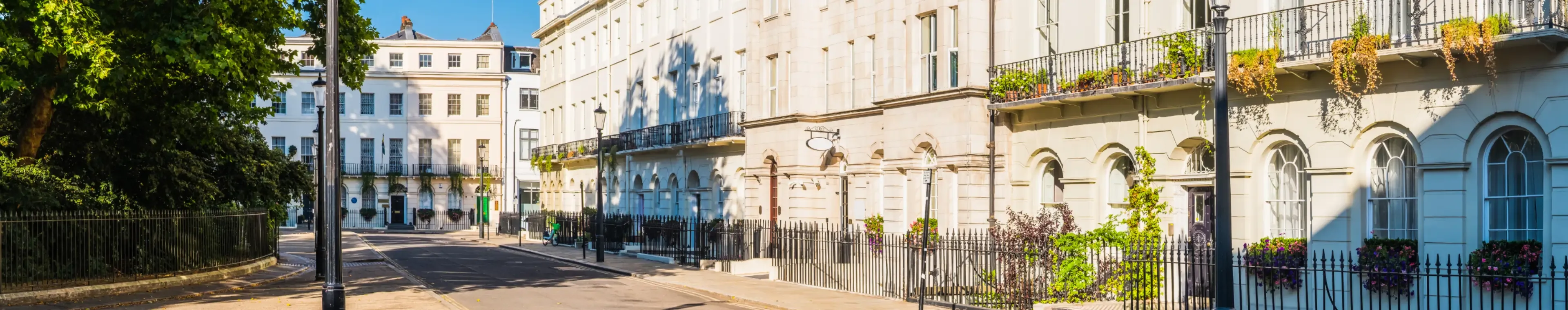 White stucco townhouses overlooking a leafy Georgian square in the heart of London, UK.