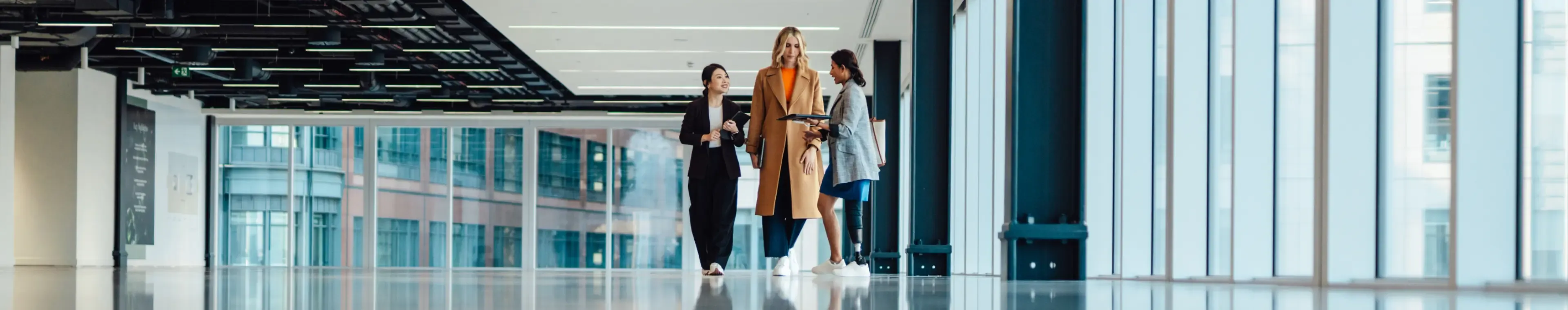 Multi racial group of businesswomen viewing new office space with an estate agent