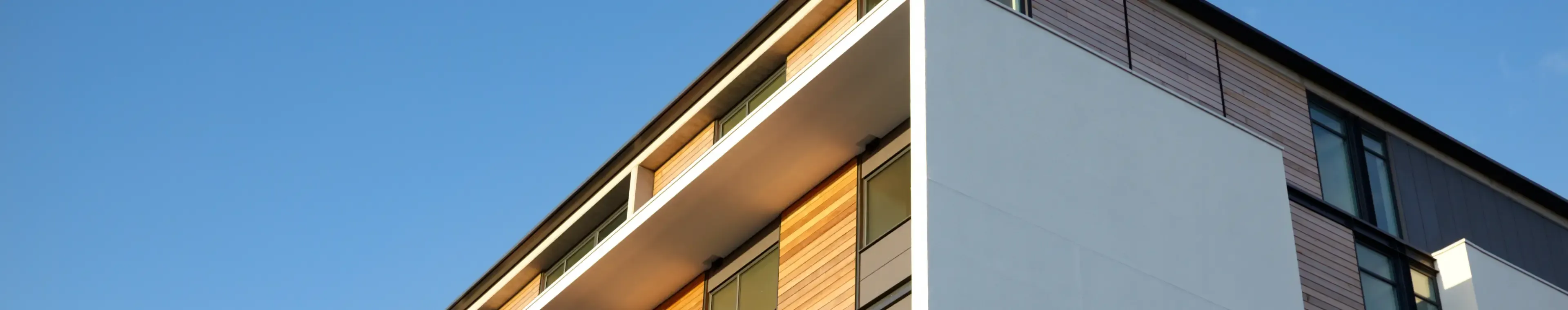 Residential apartment with wood panels and blue clear sky - Salford Quays, Salford, Manchester, England, UK